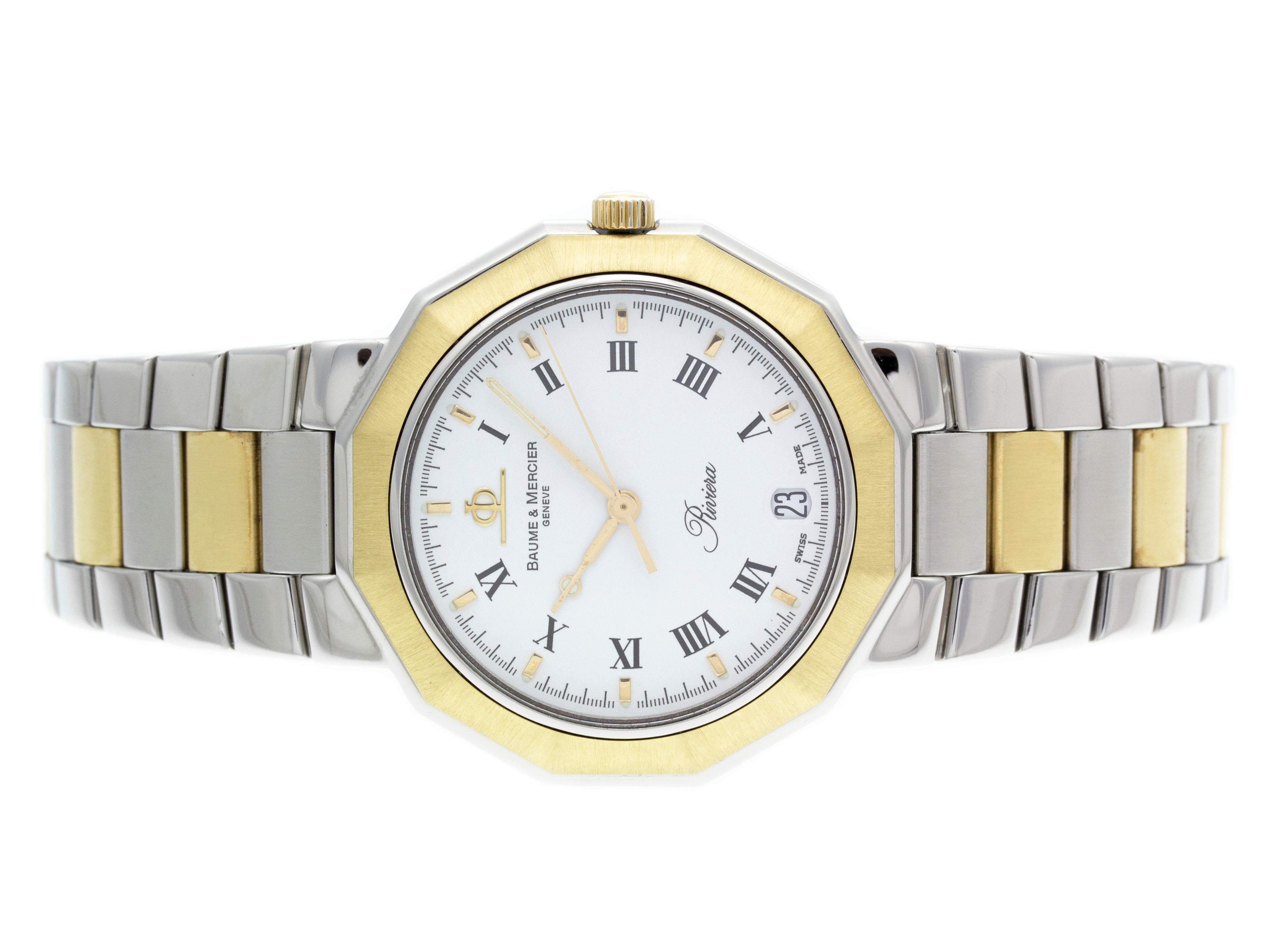 Stainless steel & 18k yellow gold Baume & Mercier quartz watch with a 36mm case, white dial, and two tone bracelet with folding clasp. Features include hours, minutes, seconds, and date. Comes with a Deluxe Gift Box and 2 Year Store