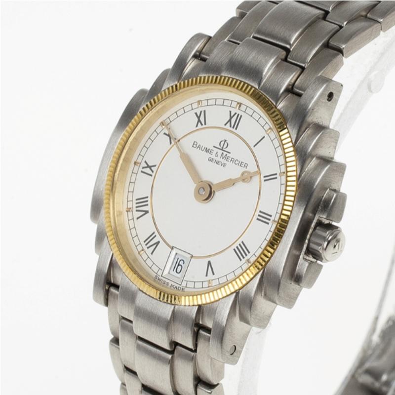 Get noticed as you flaunt this elegant watch on you wrist. Crafted from stainless steel, this Baume & Mercier timepiece features a white dial with Roman numerals hands and a date window. Water resistant up to 30 meters, it showcases a bezel in gold