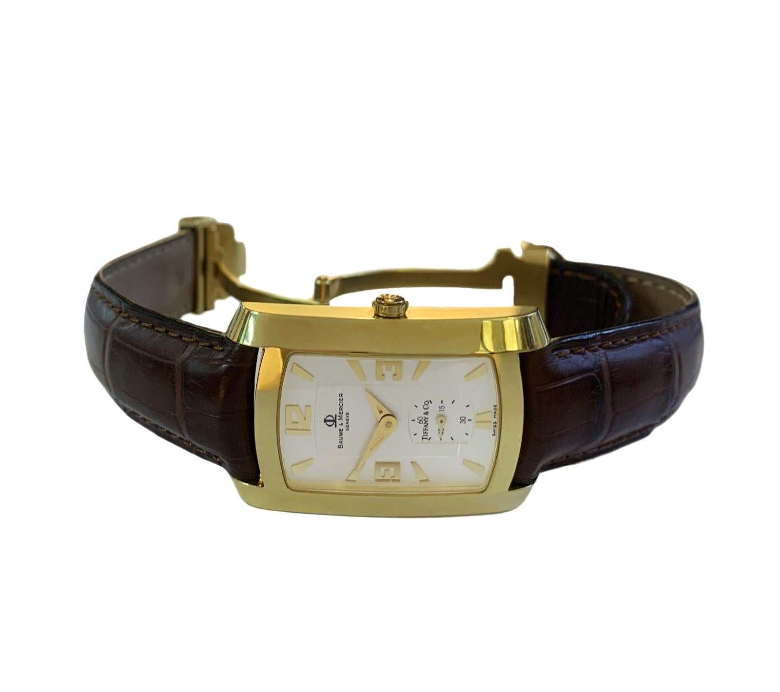 BAUME & MERCIER TIFFANY 18K GOLD HAMPTON WATCH WV045224

-Mint condition, strap shows signs of wear
-Case Size: 26x40 mm
-Case Thickness: 7 mm
-Case Material: 18kt Yellow Gold
-Movement: Quartz 
-Weight: 49.8gr
-Buckle: Stainless steel
-Dial color :