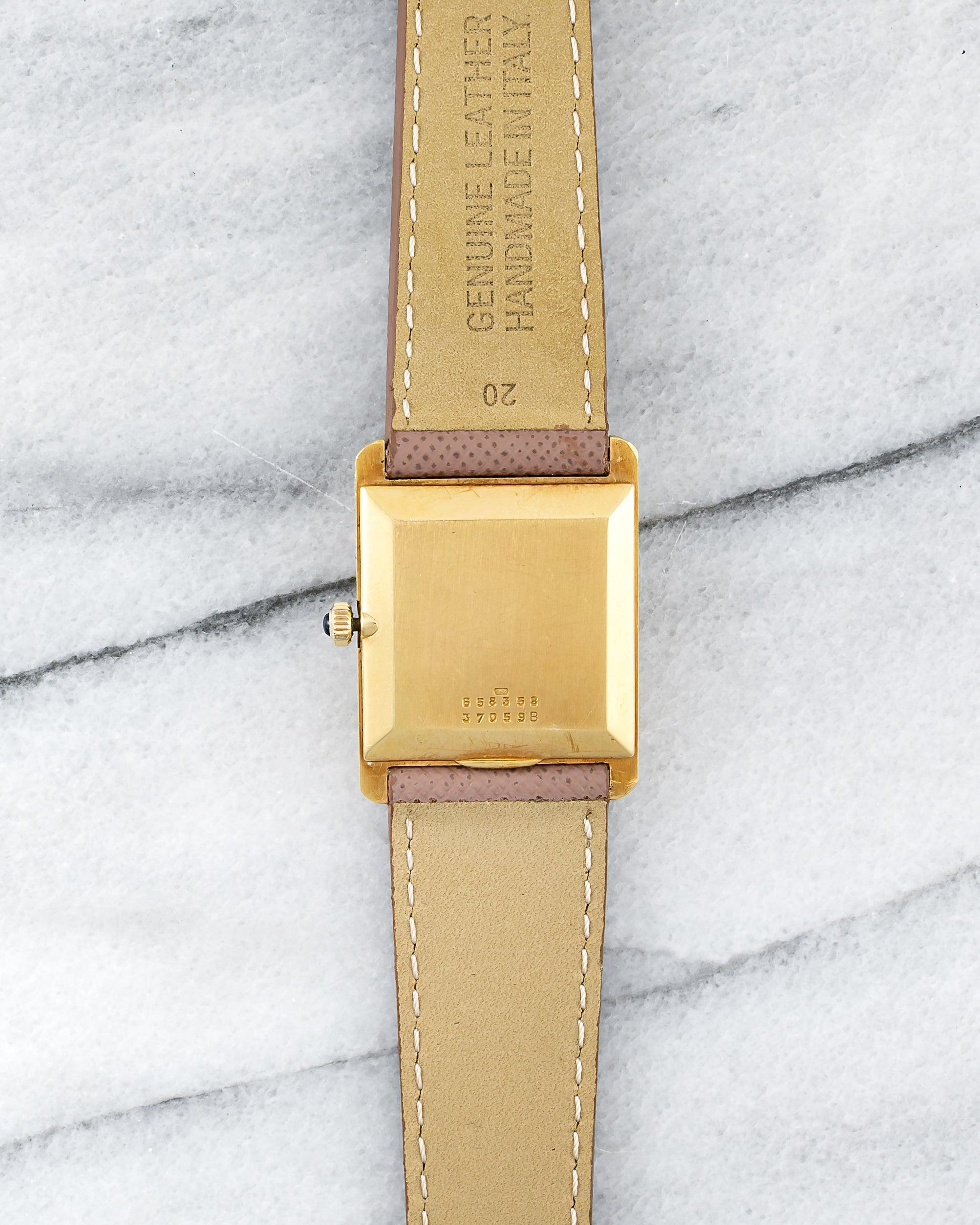 Here's a vintage Baume & Mercier tank manual wind in 18K yellow gold with a brown tiger eye stone dial from the 1970s. It keeps great time and is fully functional. Measurements include a 25mm case and 20mm lug width. It's on an aftermarket grey