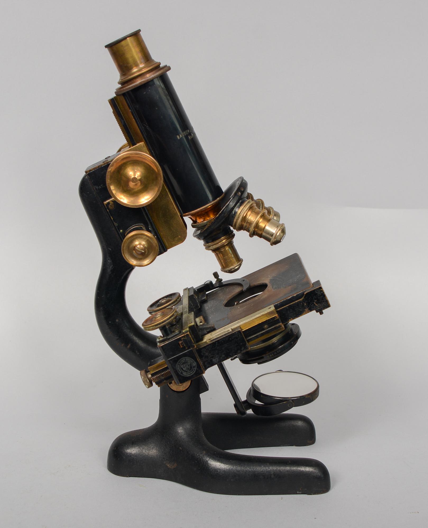 Brass Bausch and Lomb microscope. There is a patent date of Jan. 5, 1915 on this. This microscope has three objectives. The stage has an adjustable slide holder. This is from an older collection belonging to a doctor. We do not know the