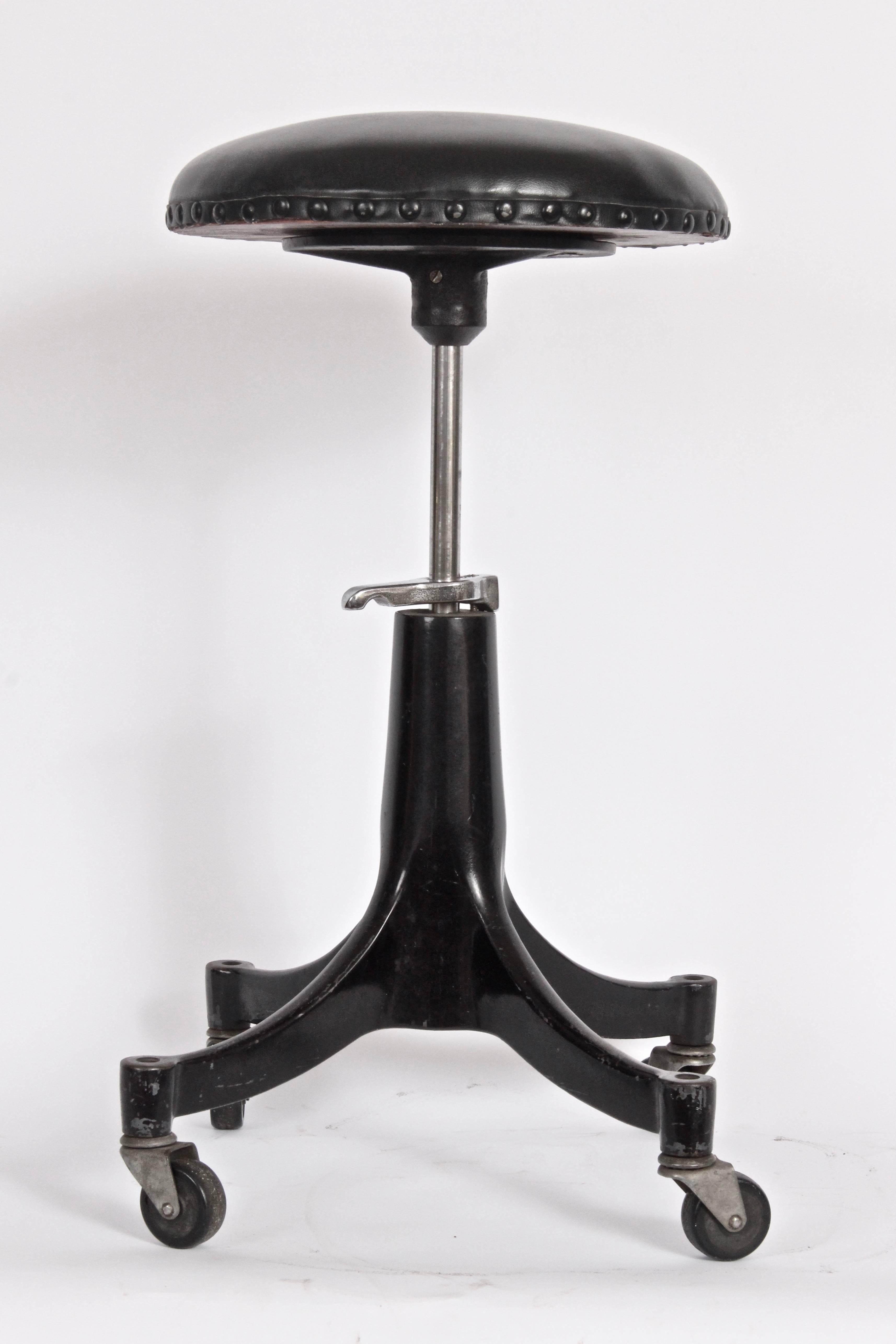 Signed Industrial Bausch and Lomb Black enameled Iron Easy Glide Optometrists Stool. Counter stool. Rounded Black vinyl cushion. Cast iron base.  With independent swivel casters. Measure: Seat diameter 13 D. Adjustable seat height 20 H-26 H.
