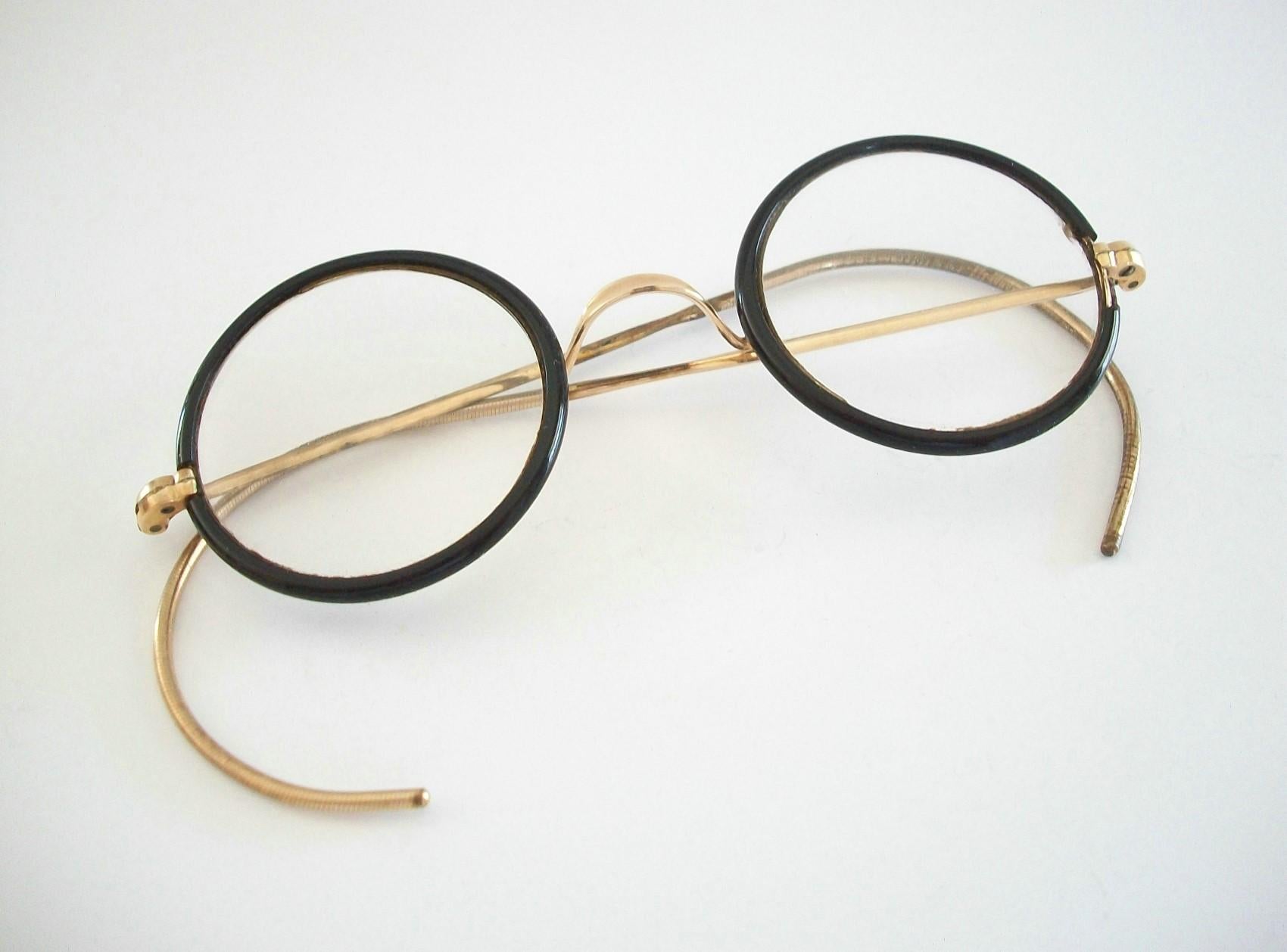 BAUSCH & LOMB - Vintage schwarz emaillierte runde Kinderbrille mit goldfarbenem Nasensteg und Bügeln - mit verschreibungspflichtigen Gläsern - hochwertige Fassung - signiert B&L (siehe Foto) - Kanada - ca. 1940er Jahre.

Guter Vintage-Zustand -
