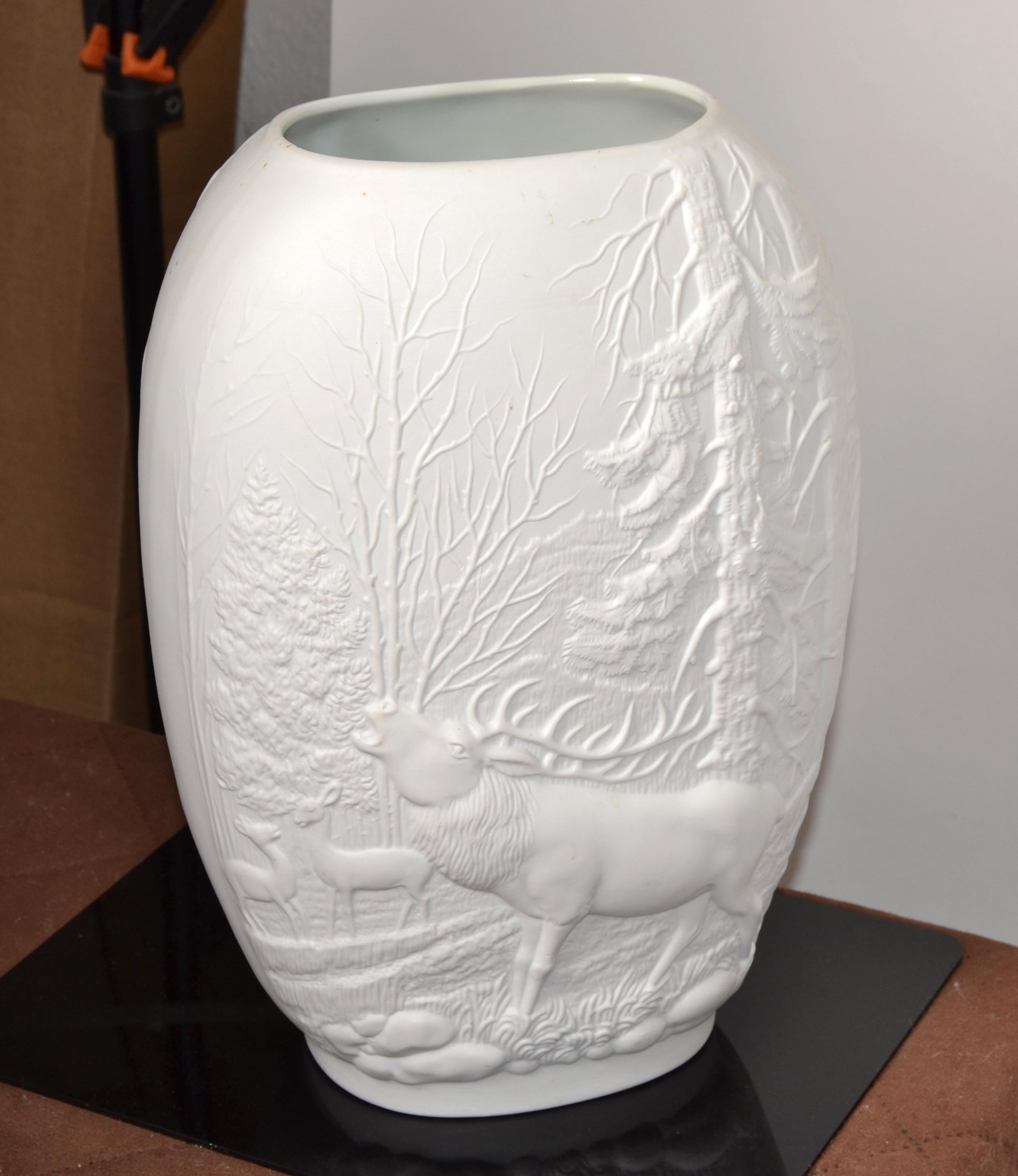 Vase à fleurs en porcelaine royale allemande Op Art Relief Decor, Rosenthal Bavaria white Bisque handmade Mid-Century Modern.
Vase en porcelaine bisque blanche avec un motif de forêt rustique de cerfs et de pins ornant ce vase ovale.
En très bon