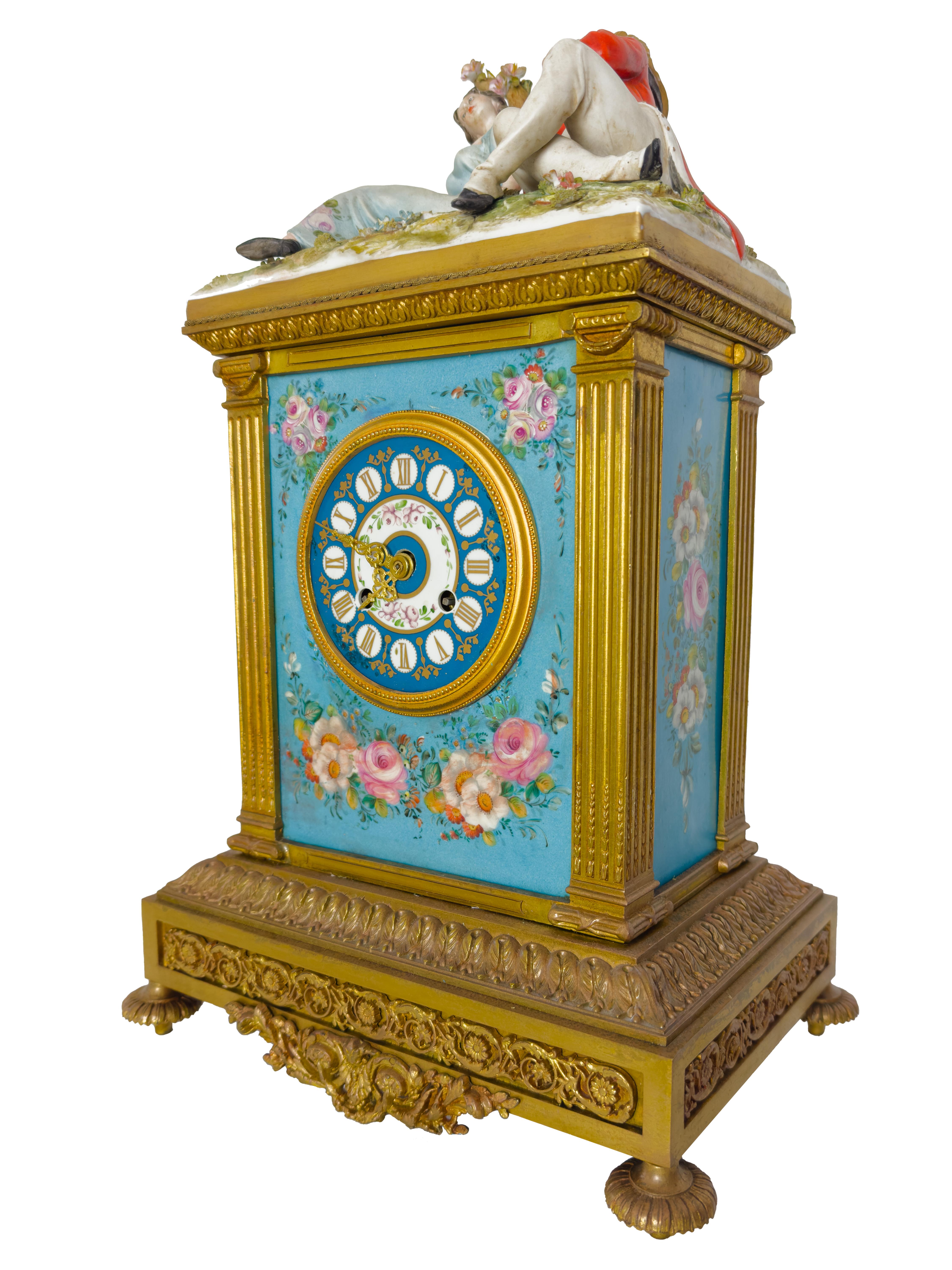 A baronette bronze clock in Capodimonte style porcelain by Tiche. 
A golden metal and blue porcelain piece ornate with a traditional Bavarian theme, decorated with flowers and topped with a couple sitting by a tree. The man is a Saxon Soldier,