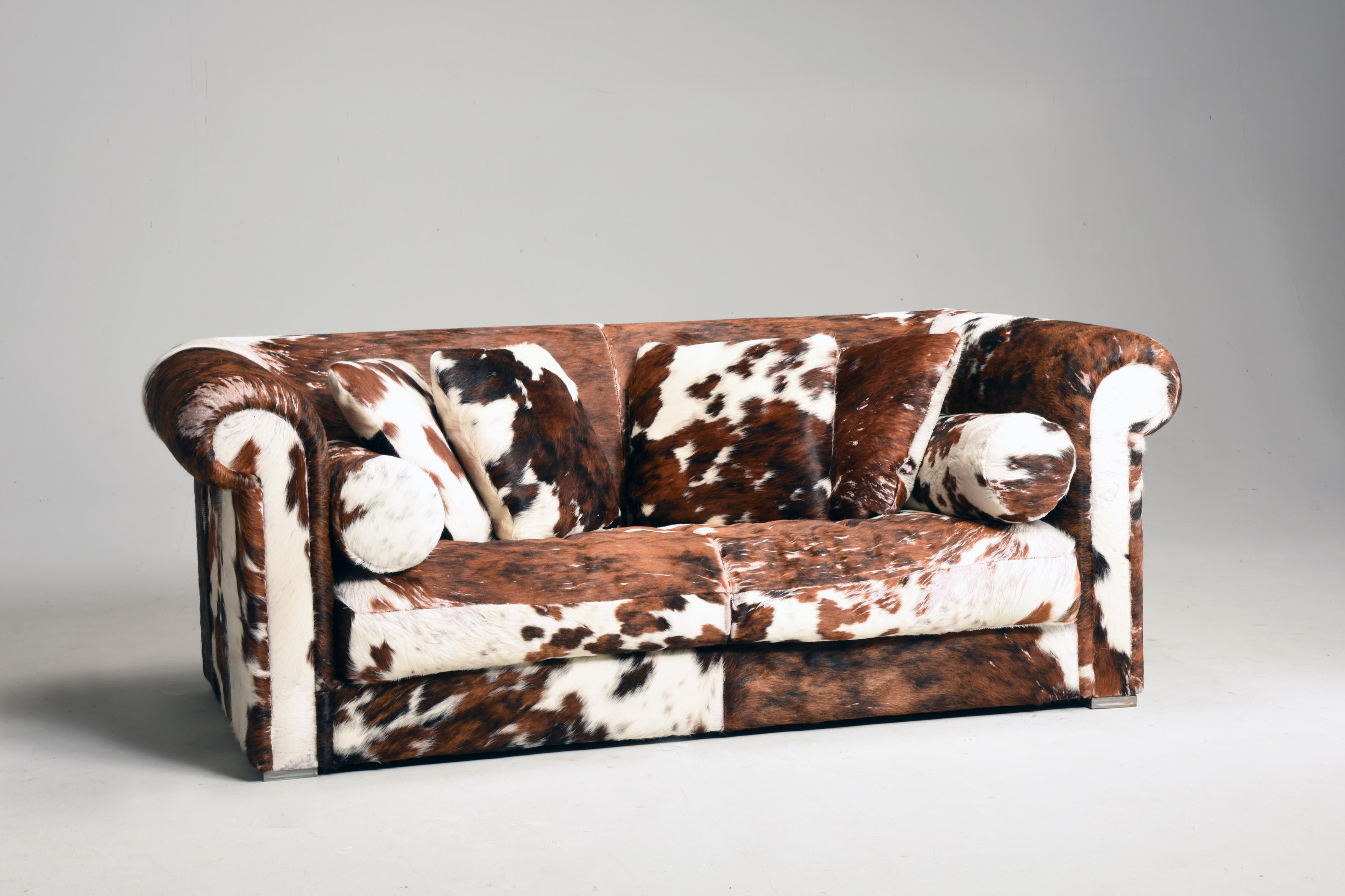 1990s Italian dappled pony skin leather sofa and pillows by Baxter. The sofa comes with a set of pillows squared and tubular shaped. They all are upholstered with pony skin leather brown and white color. This kind of sofa is ideal in a very modern