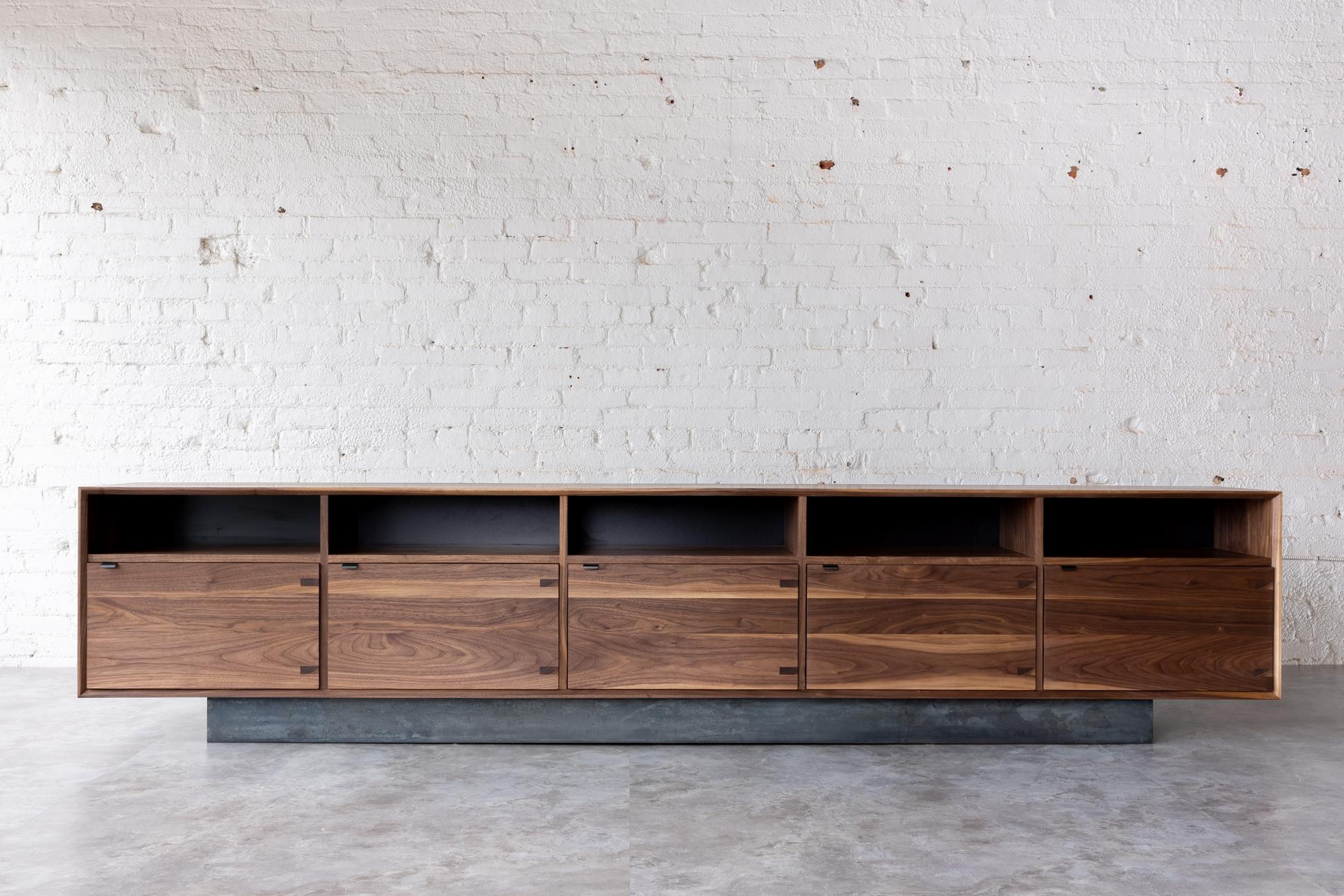 The Baxter Long Credenza has a low and lean profile for a total of 10 feet long, showcasing five cabinet doors and open upper storage.

The contemporary credenza uses solid black walnut constructed with, an uncommonly practiced, entirely solid wood
