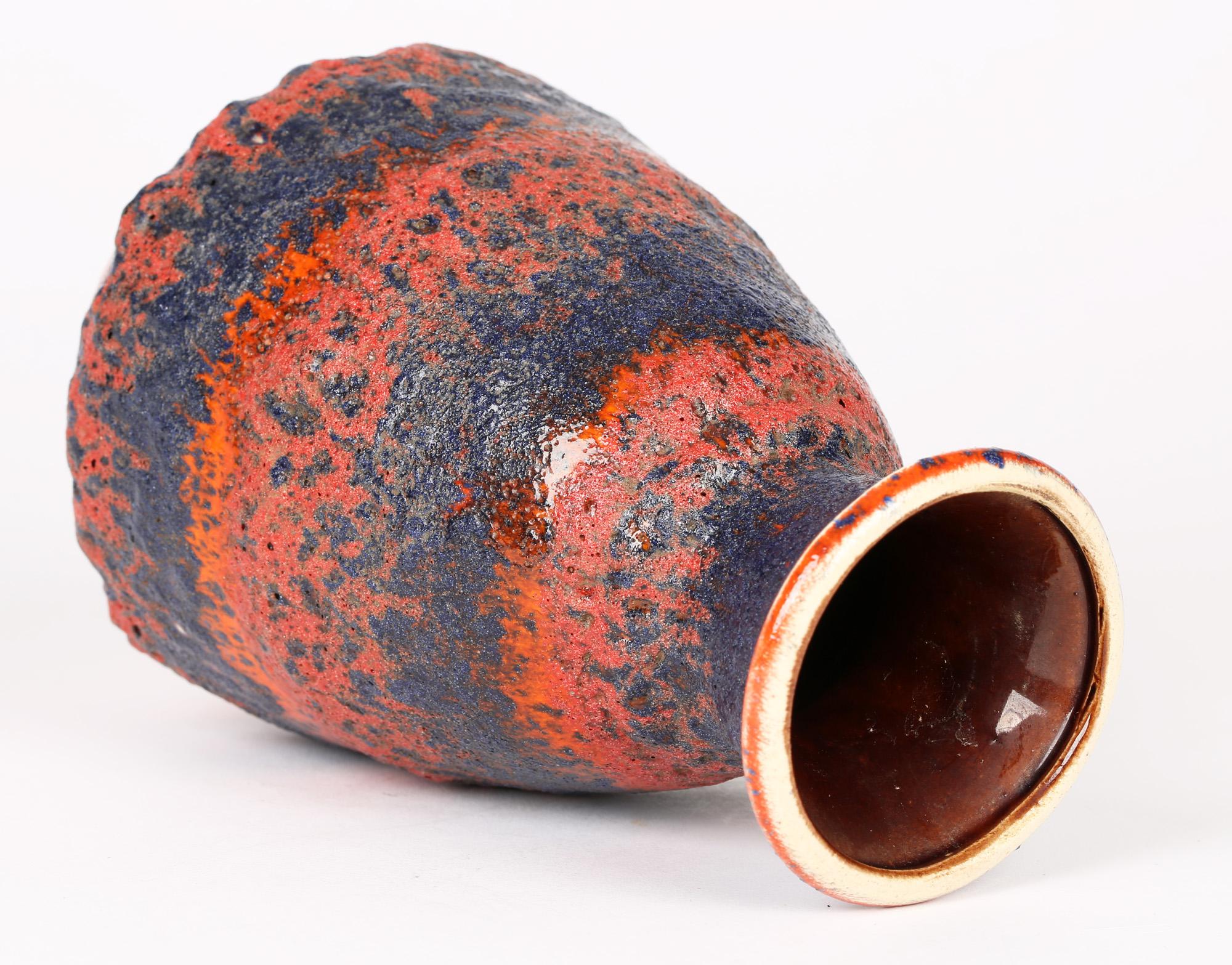 A very stylish German mid-century art pottery vase decorated in volcanic and fat lava glazes by Bay Keramik. The bell shaped vase stands on a narrow rounded unglazed foot rim with a recessed base and with a bell shaped body and short trumpet shaped