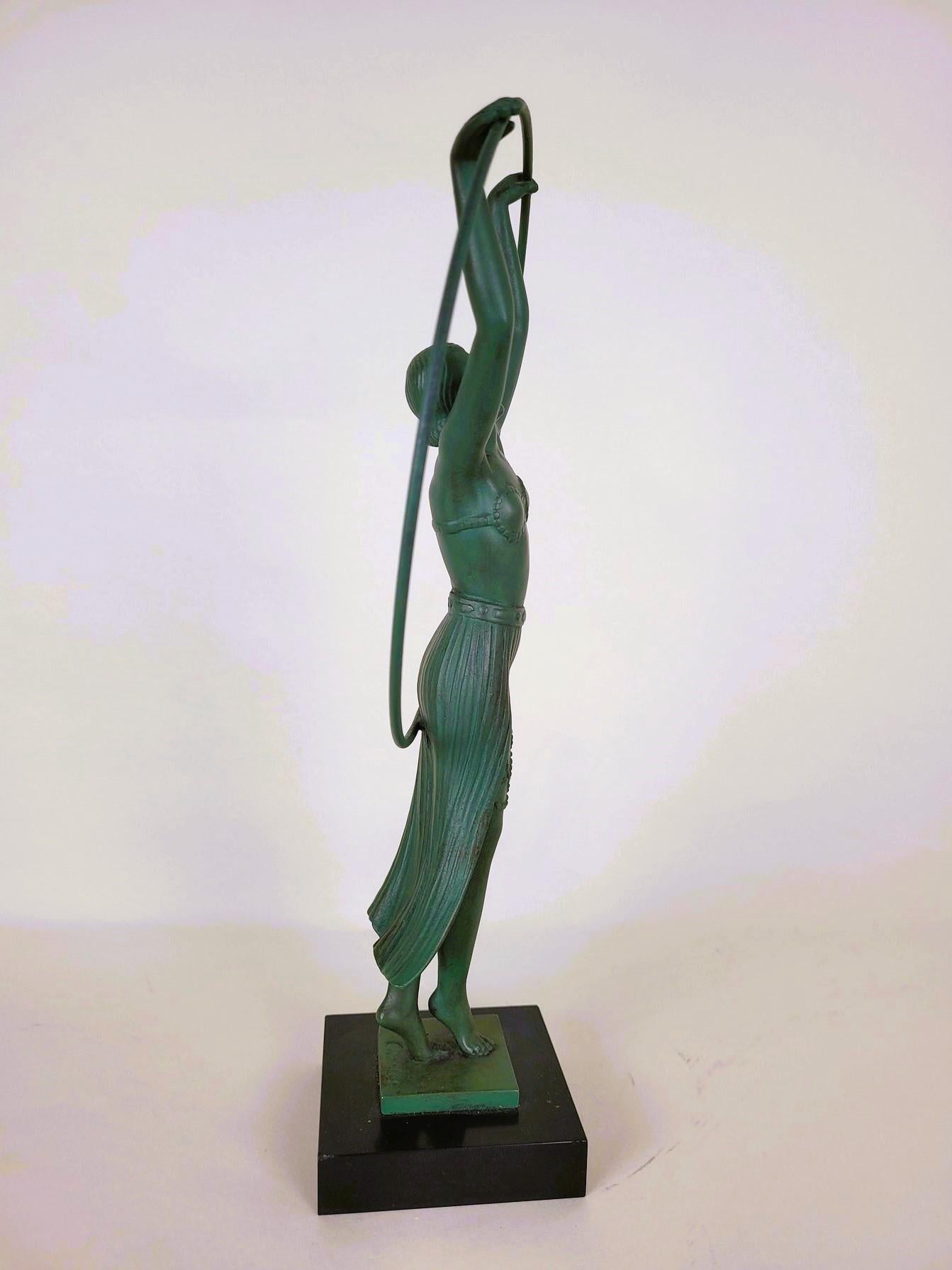 La Bayadère: Sculpture representing a dancer with a hoop, dressed in an exotic costume, and inspired by the ballet character created by Marius Petitpa

Green patina spelter on a marble base, the counter-base is signed by the artist Charles, and was