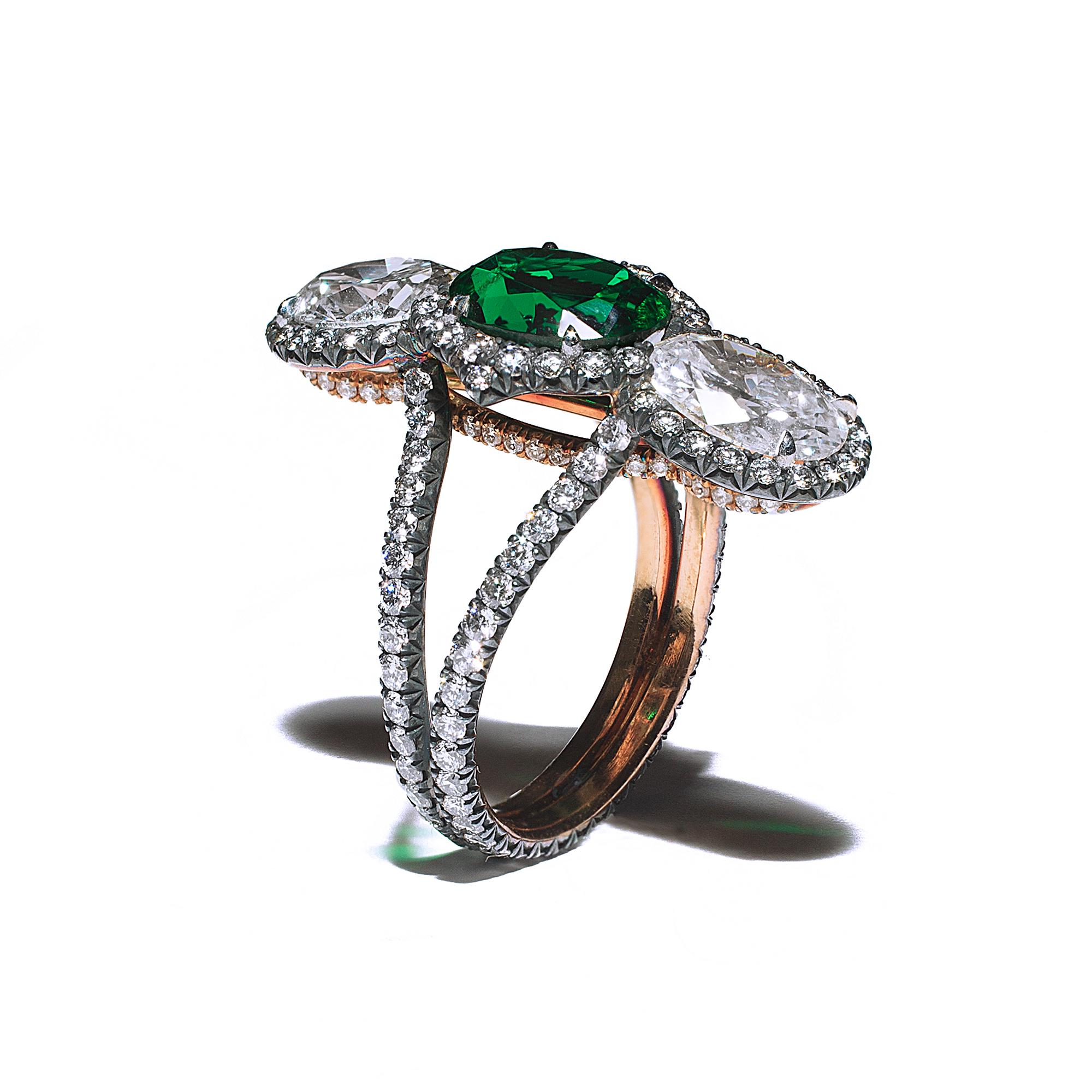 A 20kt rose gold & oxidized silver ring centered upon a 1.95 carat oval “no oil” Zambian emerald, certified by GIA and C. Dunaigre, designed in a vertical style and set with two oval diamonds weighing 2.43 carts total of G color and VS1 and VVS2