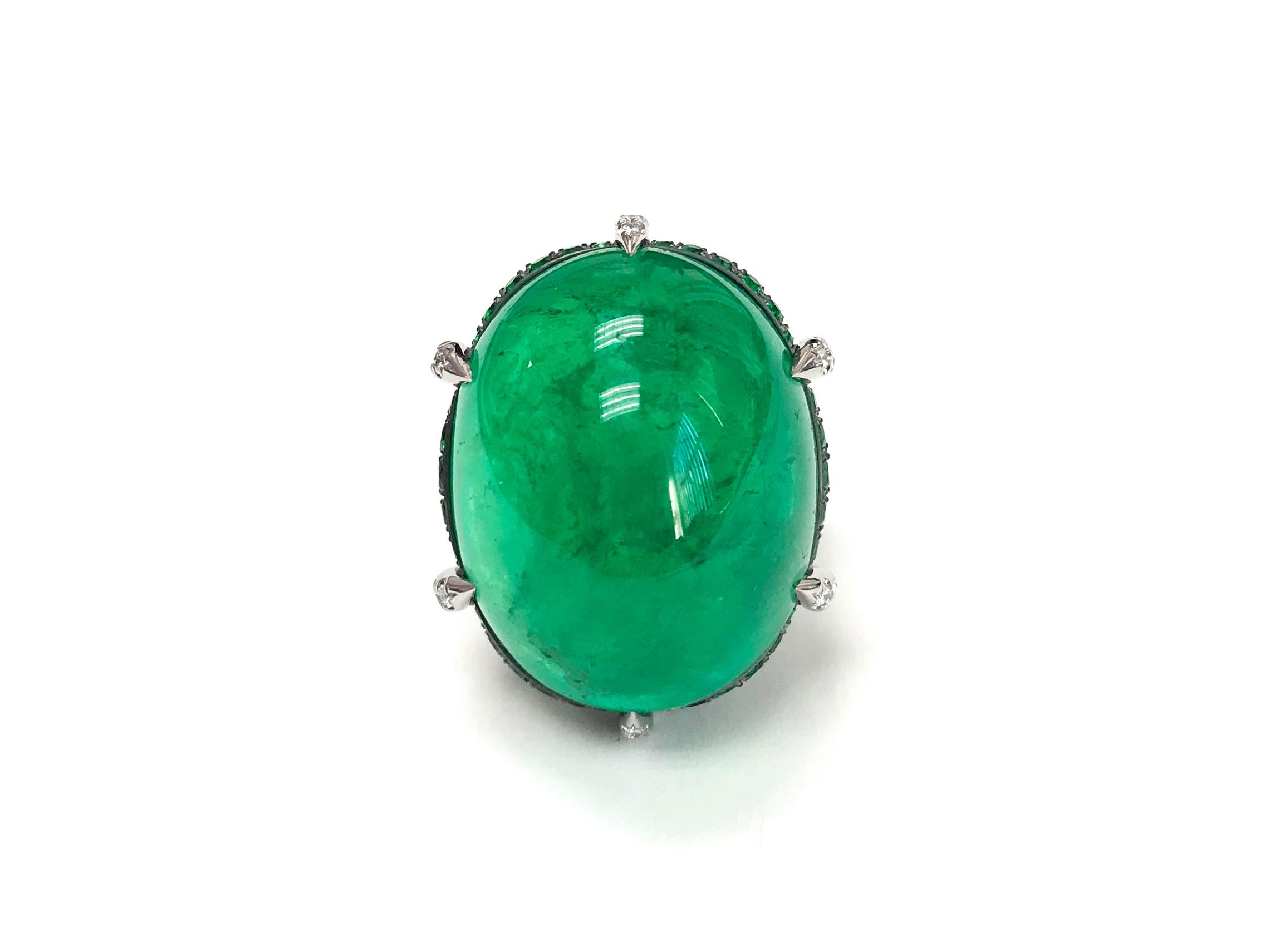 A unique platinum and oxidized silver ring centered upon an impressive 43.50 carat cabochon Colombian emerald, certified by C. Dunaigre Consulting, set atop a cushion of pavé emeralds weighing 2.32 carats total and all set within a colorless diamond