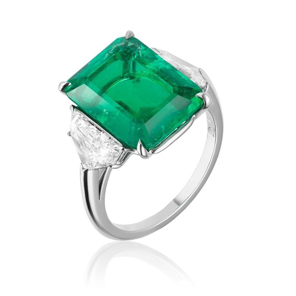 A platinum ring centered upon an extremely rare 6.85 carat un-enhanced emerald-cut Old-Mine Colombian emerald, certified by GRS and C. Dunaigre, flanked by colorless epaulet diamonds weighing 1.30 carats total. 

Emeralds are commonly clarity