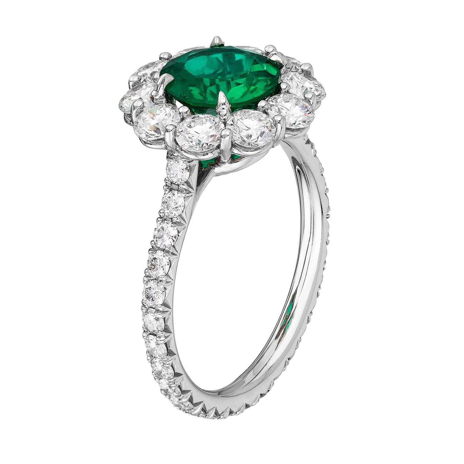 A platinum ring centered upon a beautiful 1.25 carat un-enhanced round Zambian emerald, certified by C. Dunaigre Consulting, set within a colorless diamond surround with colorless diamond micropavé on the shank. Total diamond weight 1.70
