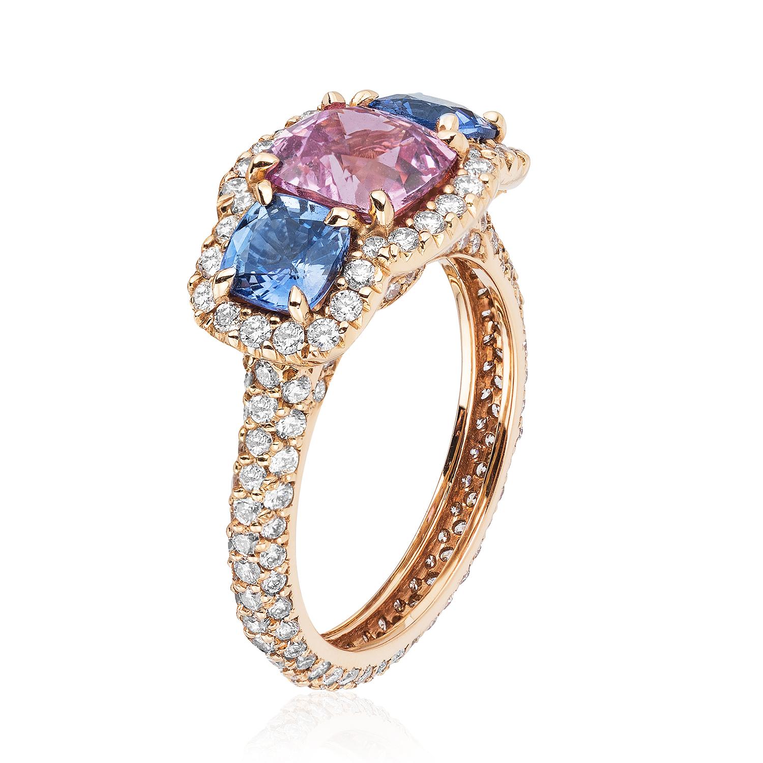 An 18kt rose-gold ring centered upon a 2.07 carat cushion pink sapphire flanked by two cushion blue sapphires weighing 1.44 carats total, certified by C. Dunaigre Consulting, set within a colorless diamond micropavé surround and colorless diamond