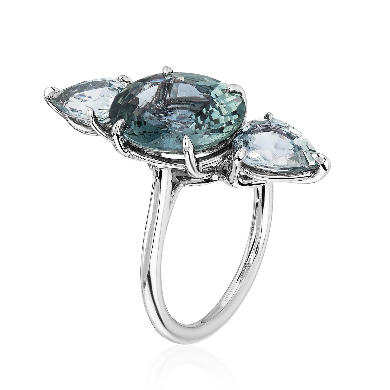 A Platinum vertical ring centered upon a 5.19 carat natural unheated oval green sapphire, certified by C. Dunaigre Consulting, set with two natural unheated pear-shaped green sapphires weighing 2.41 carats total.

Finding the right melange of colors