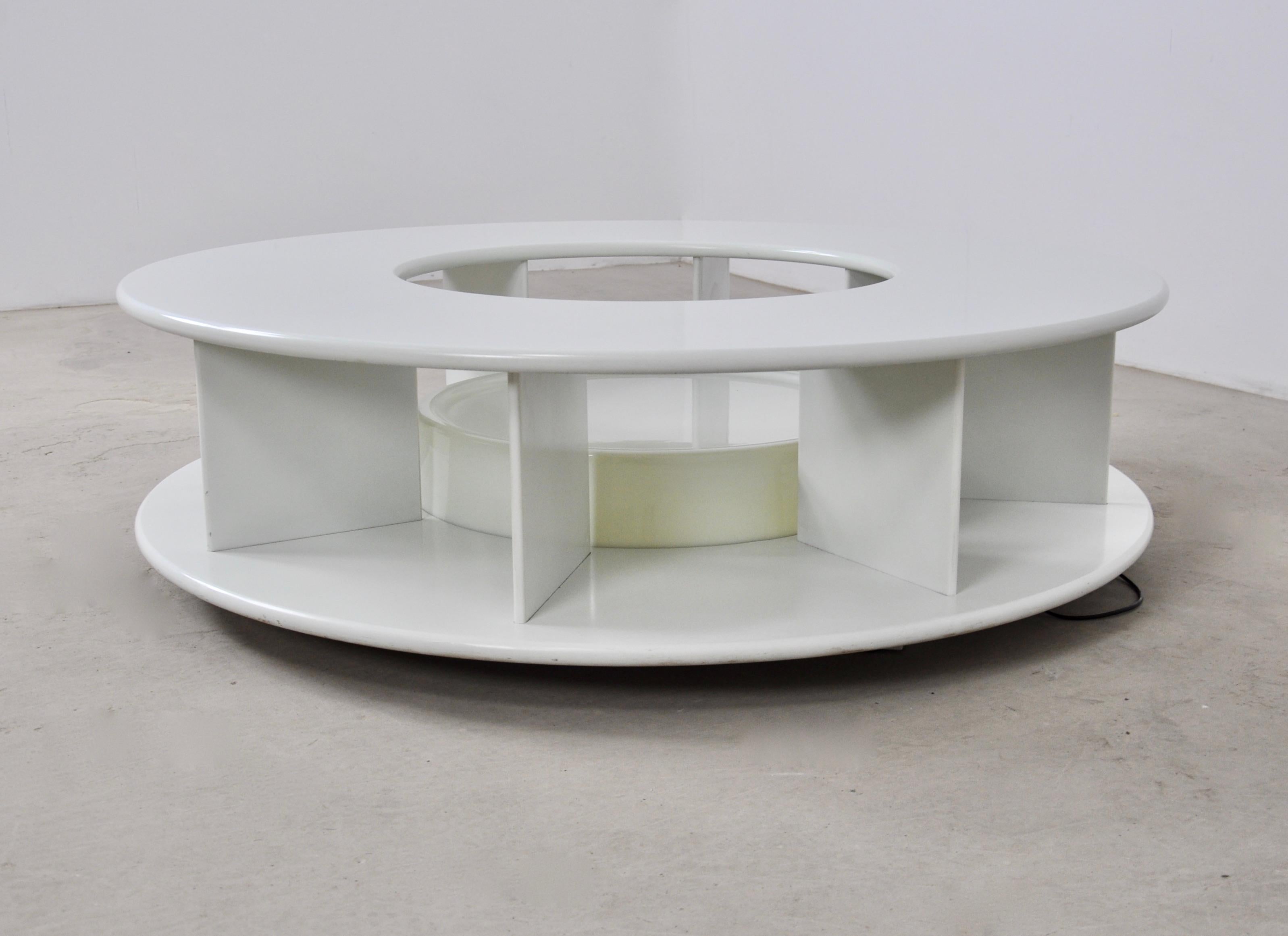 Round coffee table in lacquered wood with lamp in the middle. The table can turn on itself. Wear due to time and age of the table.