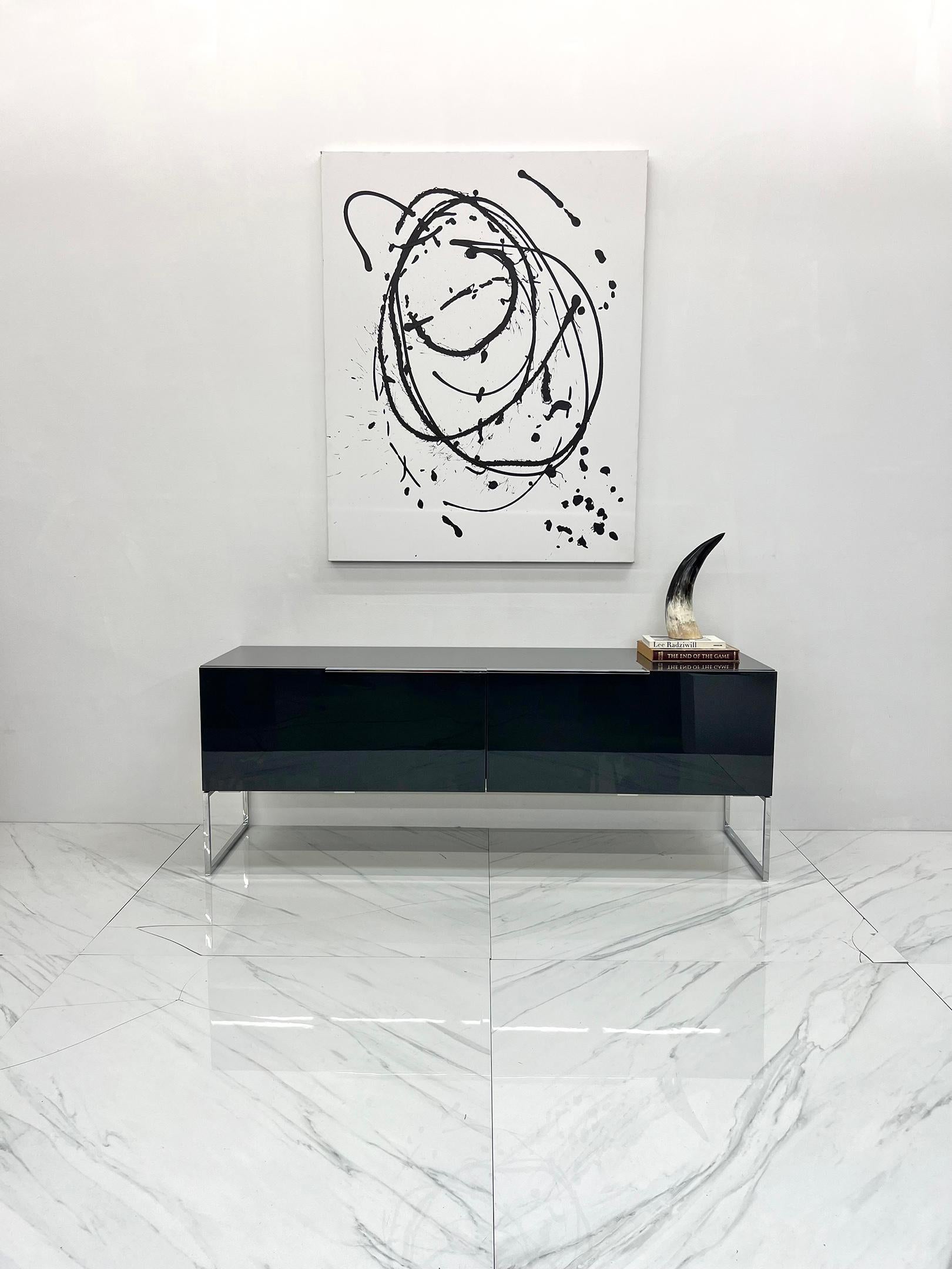 Available right now i have an Athos credenza by Paolo Piva for B&B Italia.

The credenza is a glossy dark grey lacquer with polished stainless legs and handles. The credenza has sliding doors and is finished on every side, so it can be floated in a