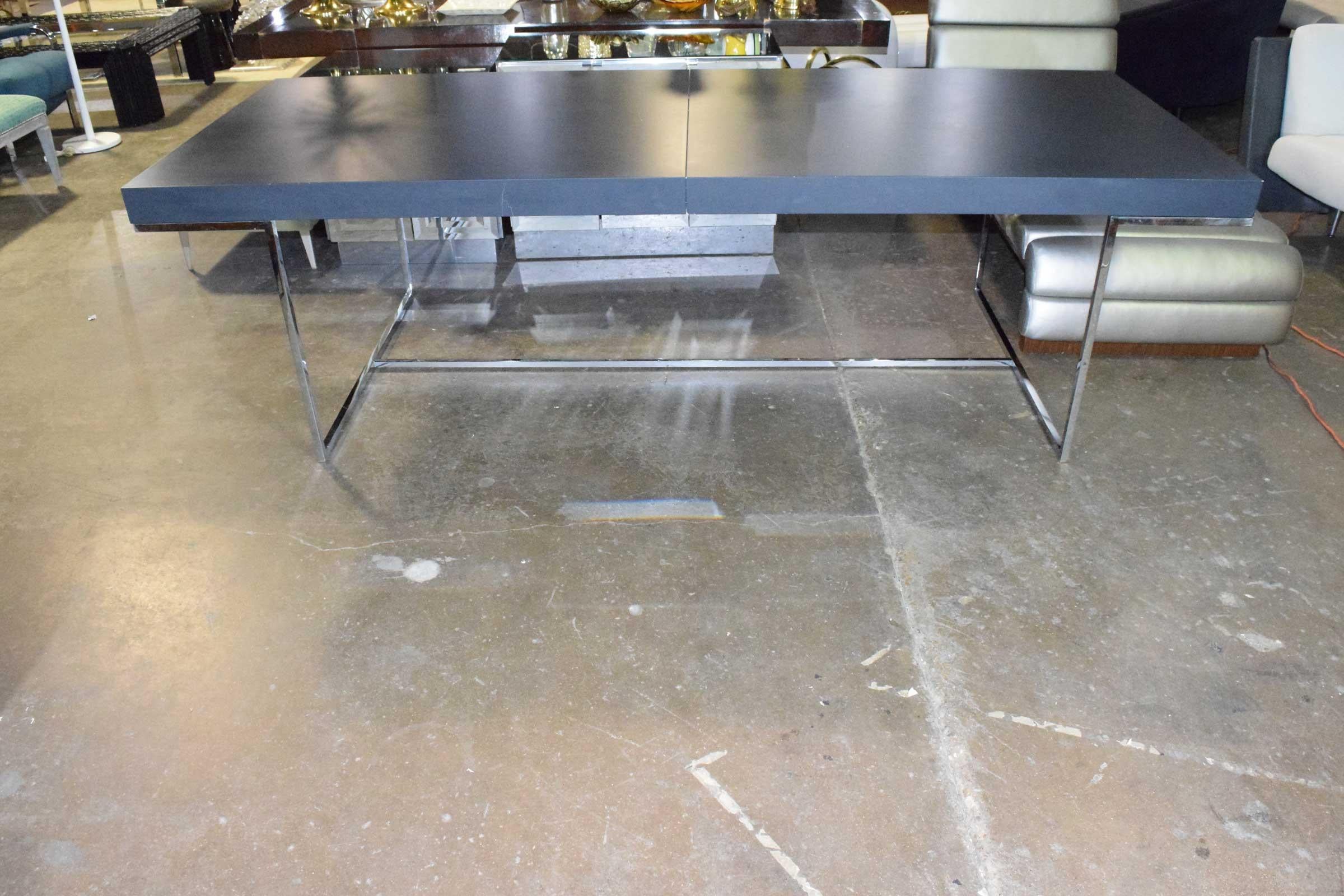 This table is no longer in production. Has a satin lacquer finish. Chrome legs. Measurements are without leaf. Hidden leaf underneath table expands table to 124.5