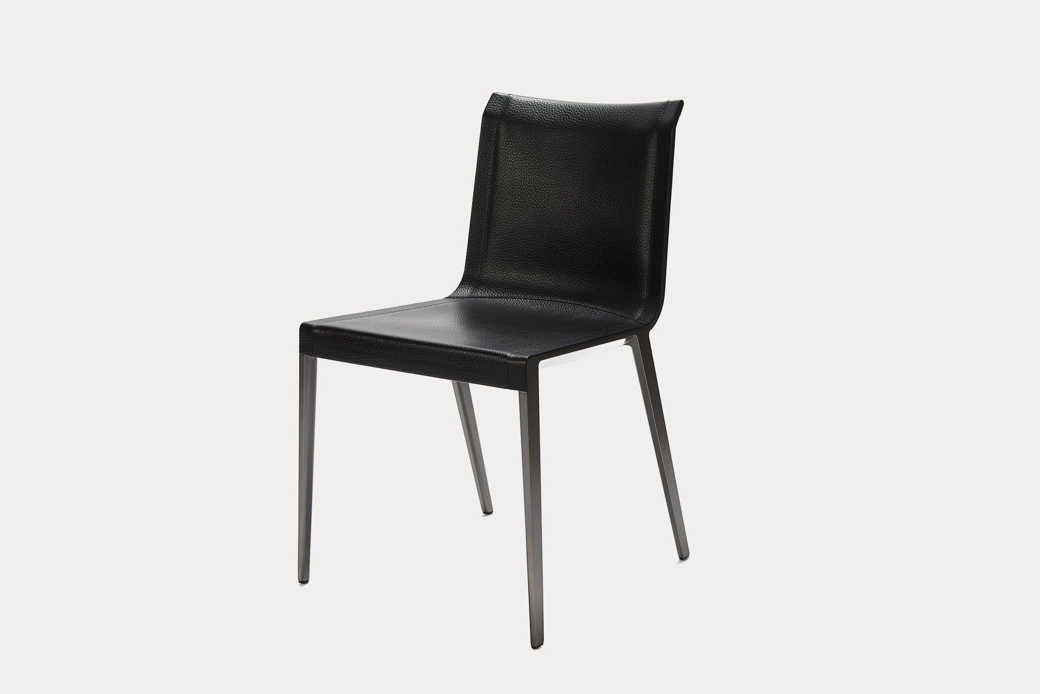 B&B Italia charlotte chair designed by Antonio Citterio is a tribute to lightness. The shell is completely covered, but the frame profile is visible on the chair side, thus highlighting the line of the seat. The cover is raw cut full grain black