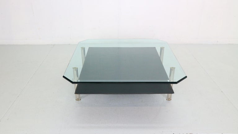 1 st edition Two tier ‘Diesis’ coffee table designed by Antonio Citterio and Paolo Nava for B&B Italia, 1970's Italy.
The upper tier is made of solid Glass and the lower tier is made of thick black leather. The frame is made of aluminium and has
