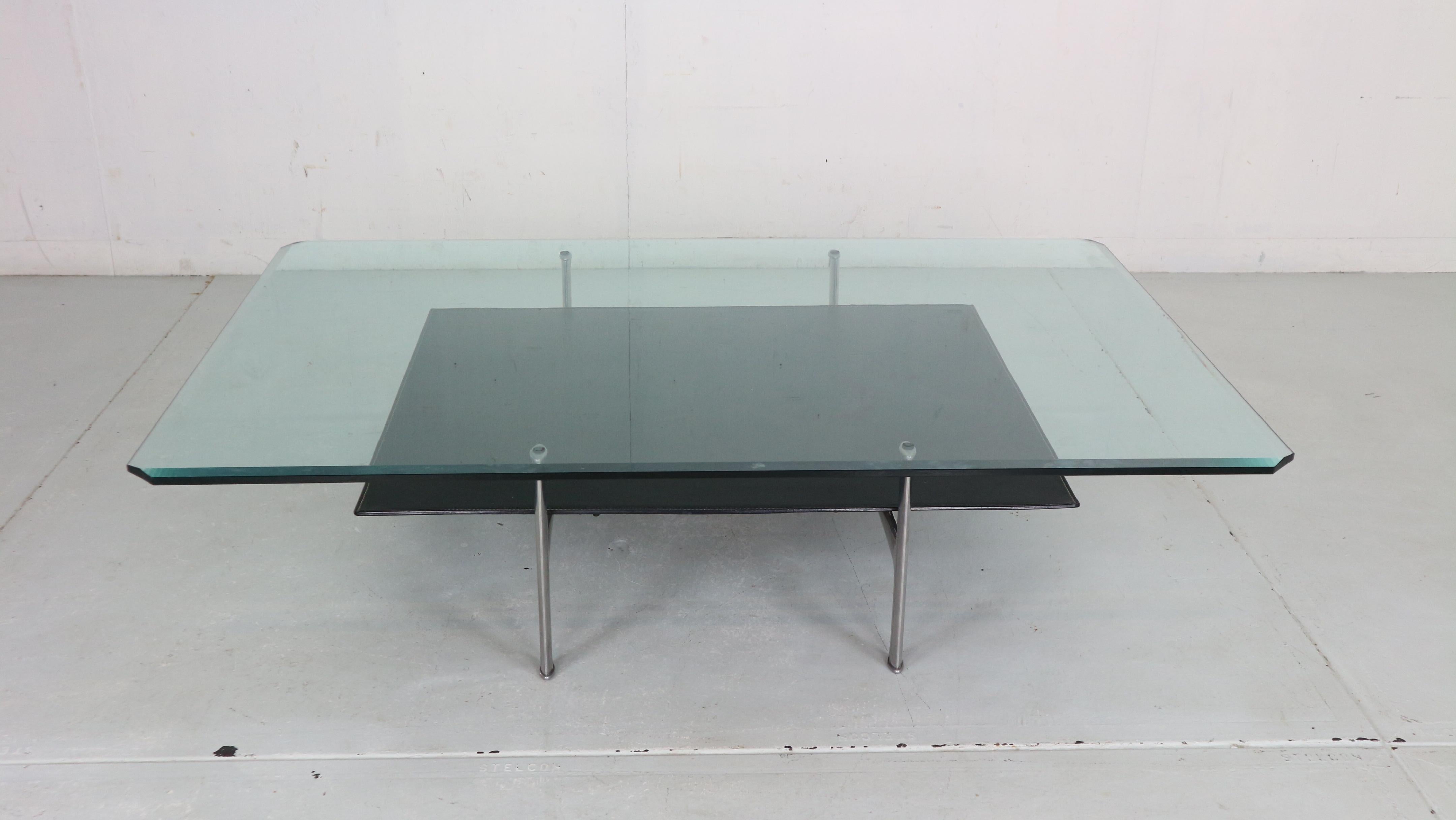 1 st edition Two tier ‘Diesis’ coffee table designed by Antonio Citterio and Paolo Nava for B&B Italia, 1970's Italy.
The upper tier is made of solid Glass and the lower tier is made of thick black leather. The frame is made of solid