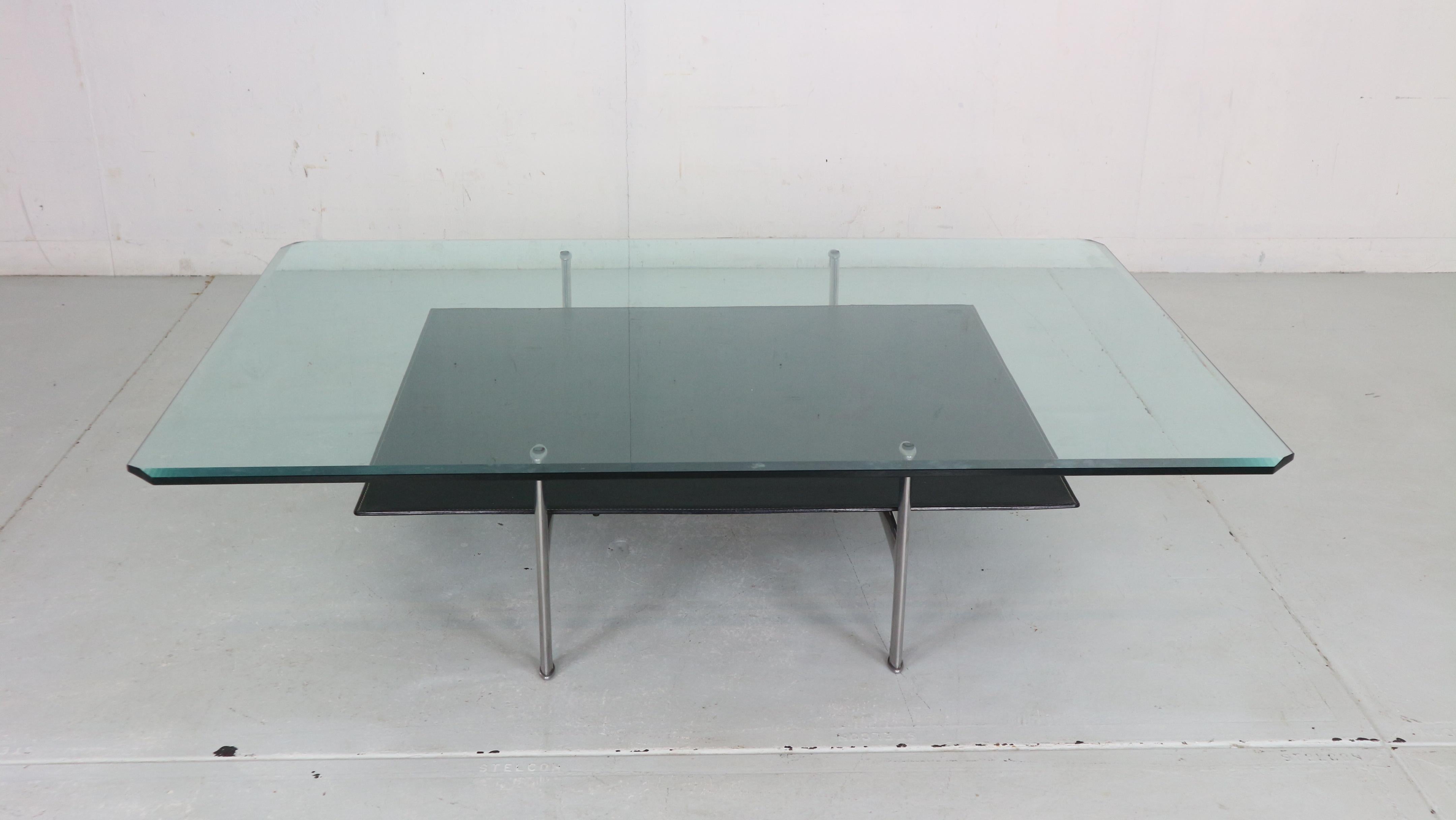 1 st edition Two tier ‘Diesis’ coffee table designed by Antonio Citterio and Paolo Nava for B&B Italia, 1970's Italy.
The upper tier is made of solid Glass and the lower tier is made of thick black leather. The frame is made of solid