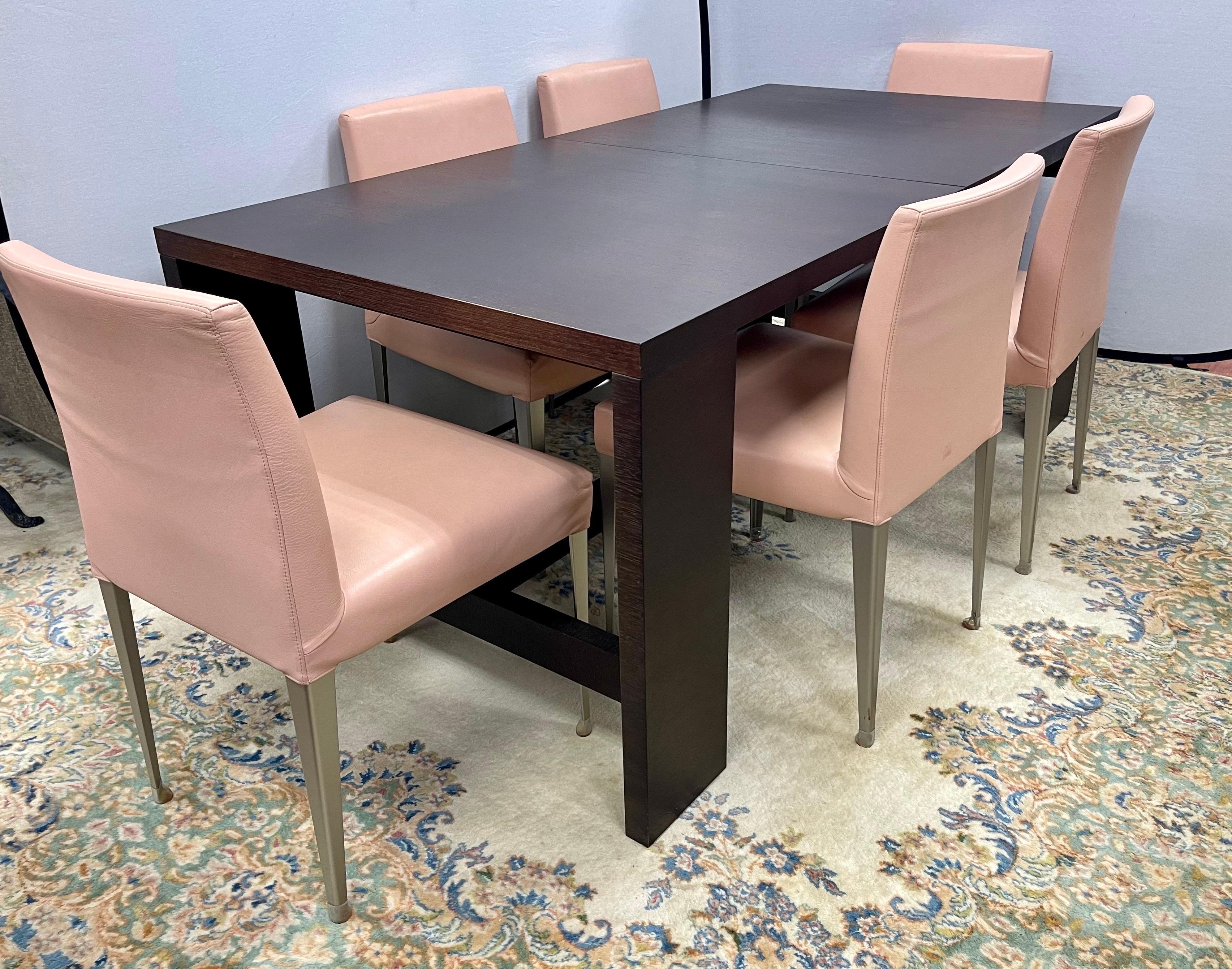 Exquisite B&B Italia dining room set with table that expands with hidden leaf attached to the underside of dining room table. Table is 71”wide without leaf inserted. Leaf is 23.5” wide.
The six chairs are a pale pink leather and have the B&B Italia