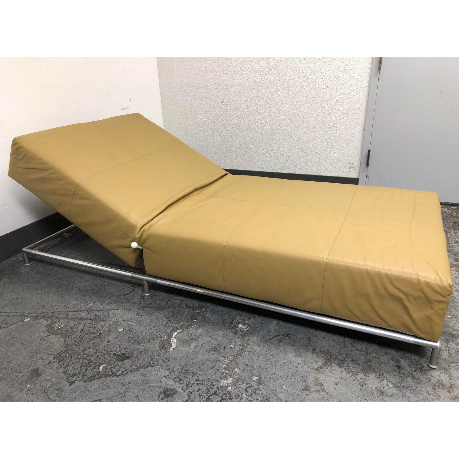 A soft gold leather chaise, from George Pouff for B&B Italia . Crafted in Italy, as only Italians can, this sleek lounge is brilliantly simple. The metal frame supports the upholstered segments that adjust for comfort. A pullout knob can adjust the