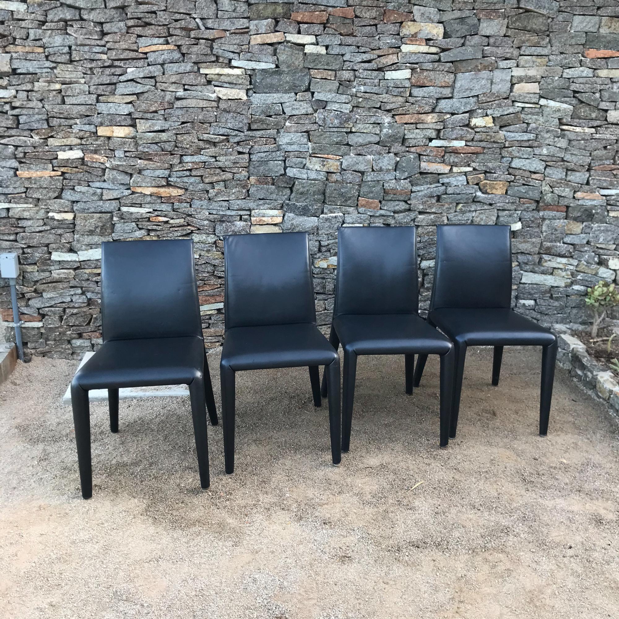 Fabulous Italian set of four dining chairs in sumptuous padded black leather designed by architect Mario Bellini for B&B Italia made in Italy.
Solid high quality modern design. Internal tubular steel frame, foam padding, covered in leather. Appears