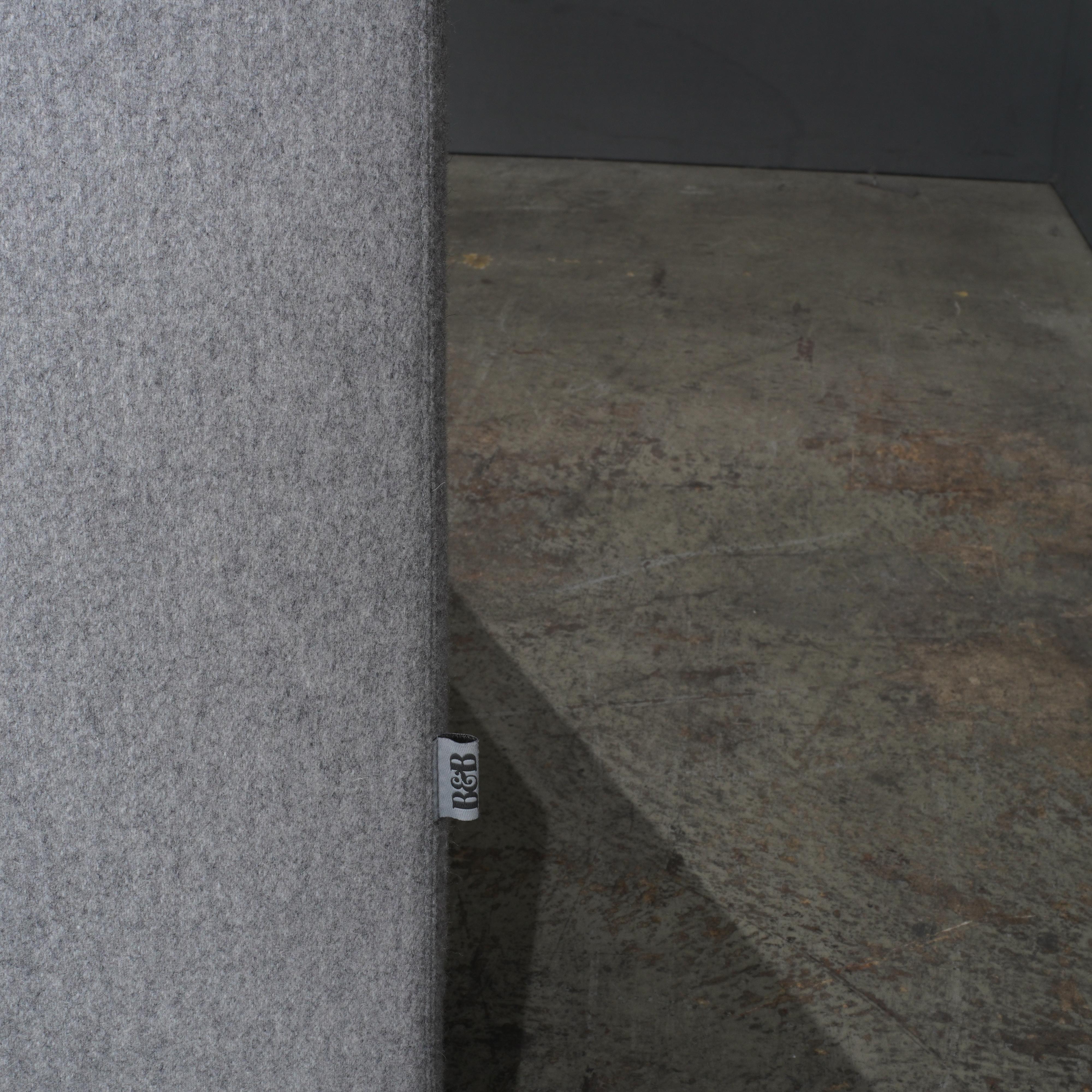 Le fauteuil gris Solo de B&B Italia est un exemple d'élégance moderne et de confort exceptionnel. Conçu avec une esthétique minimaliste, ce fauteuil spacieux présente des lignes épurées et un tissu gris doucement taillé qui s'intègre parfaitement