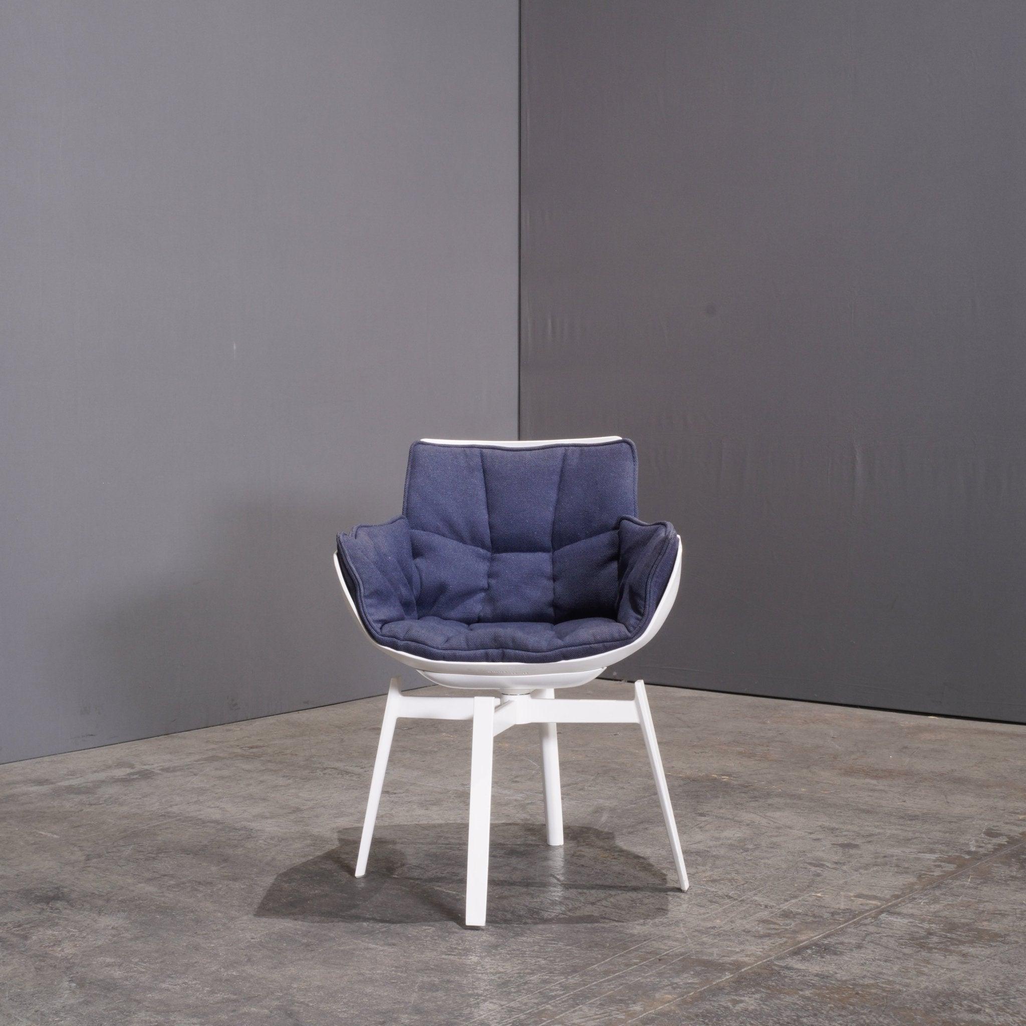 The B&B Italia White Swivel Husk Chair by Patricia Urquiola is a masterful blend of comfort and contemporary design. Upholstered in crisp white fabric, the chair features a distinctive quilted shell that envelops the user in luxurious softness. The