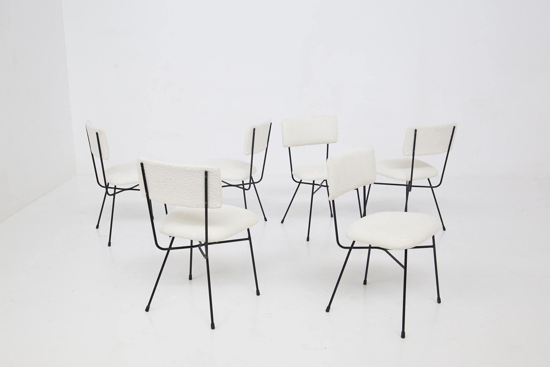 Important set of vintage iron and bouclé chairs designed by BBPR studio in the 1950s, fine Italian manufacture.
The chairs are made with a black iron frame, very geometric. The supporting structure of the back extends to below the seat of the chair