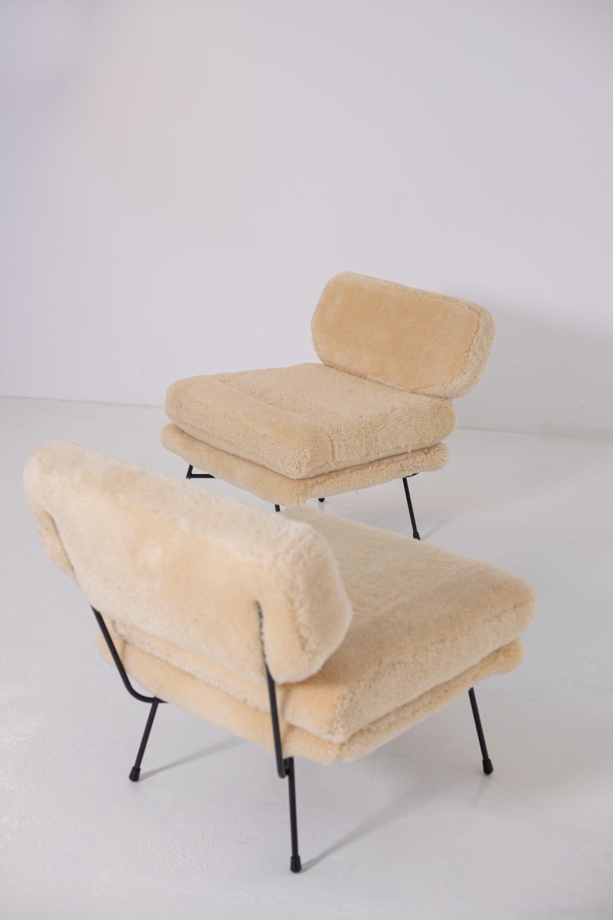 Elegant pair of armchairs by BBPR studio from the 1950s. The pair of armchairs have been refreshed in a warm, soft Italian sheepskin. Its frame is made of black painted iron. In the feet we find rubber tips to keep the armchair firmly in place.
The