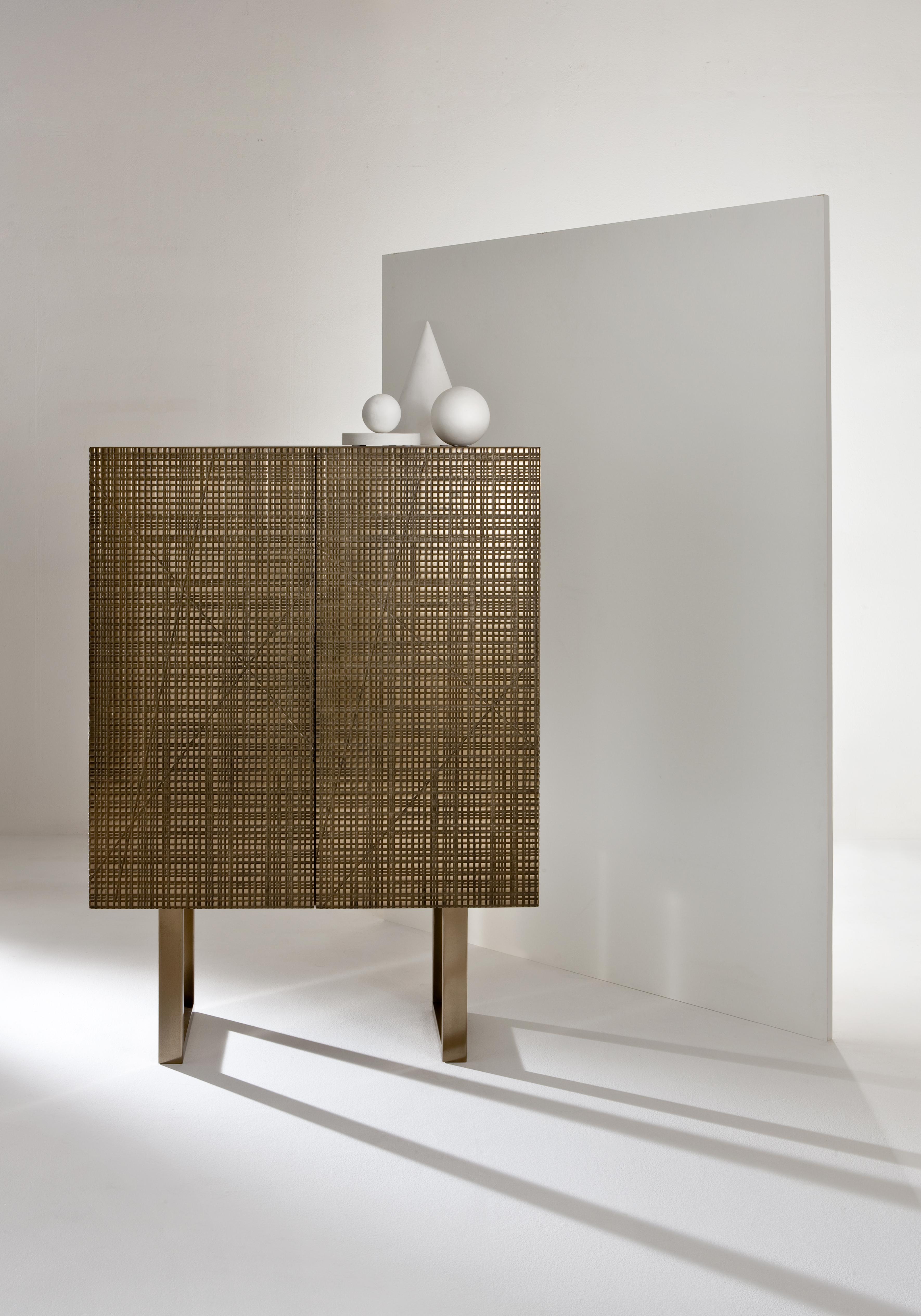 BD 95 Sideboard by Laurameroni
Dimensions: W 110 x D 48 x H 150 cm
Materials: Liquid Metal Bronze on Maxima carving; int. walnut Canaletto

Wooden tall sideboard with Maxima carved hinged doors and structure covered in liquid metal bronze. Legs and