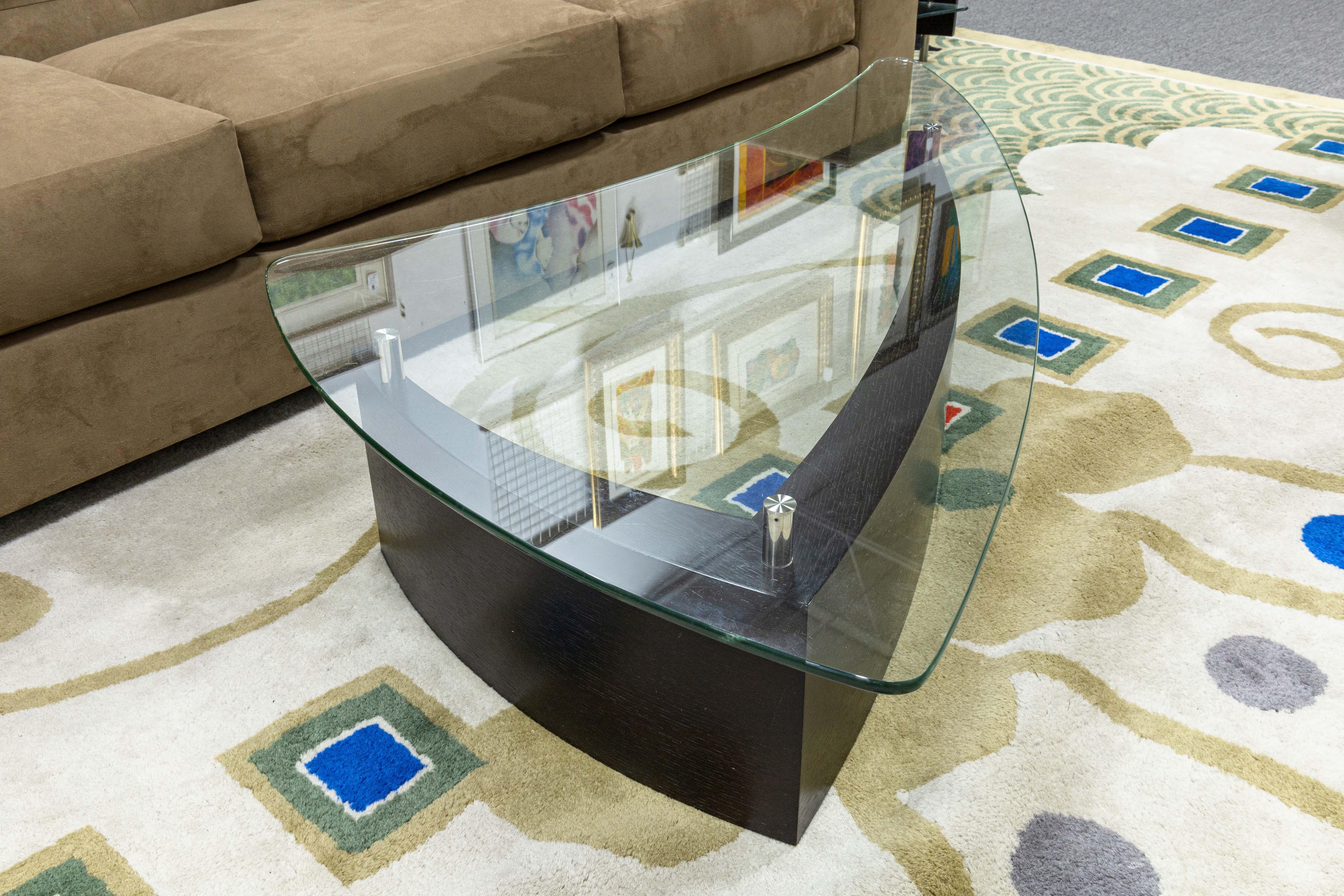 A BDI Furniture Fin 1106 coffee table. A wonderful piece of contemporary modern furniture designed by Cristian Wicha for BDI. This surfboard inspired piece features a fin-like freeform shape design with a stained dark oak wood base, satin-nickel