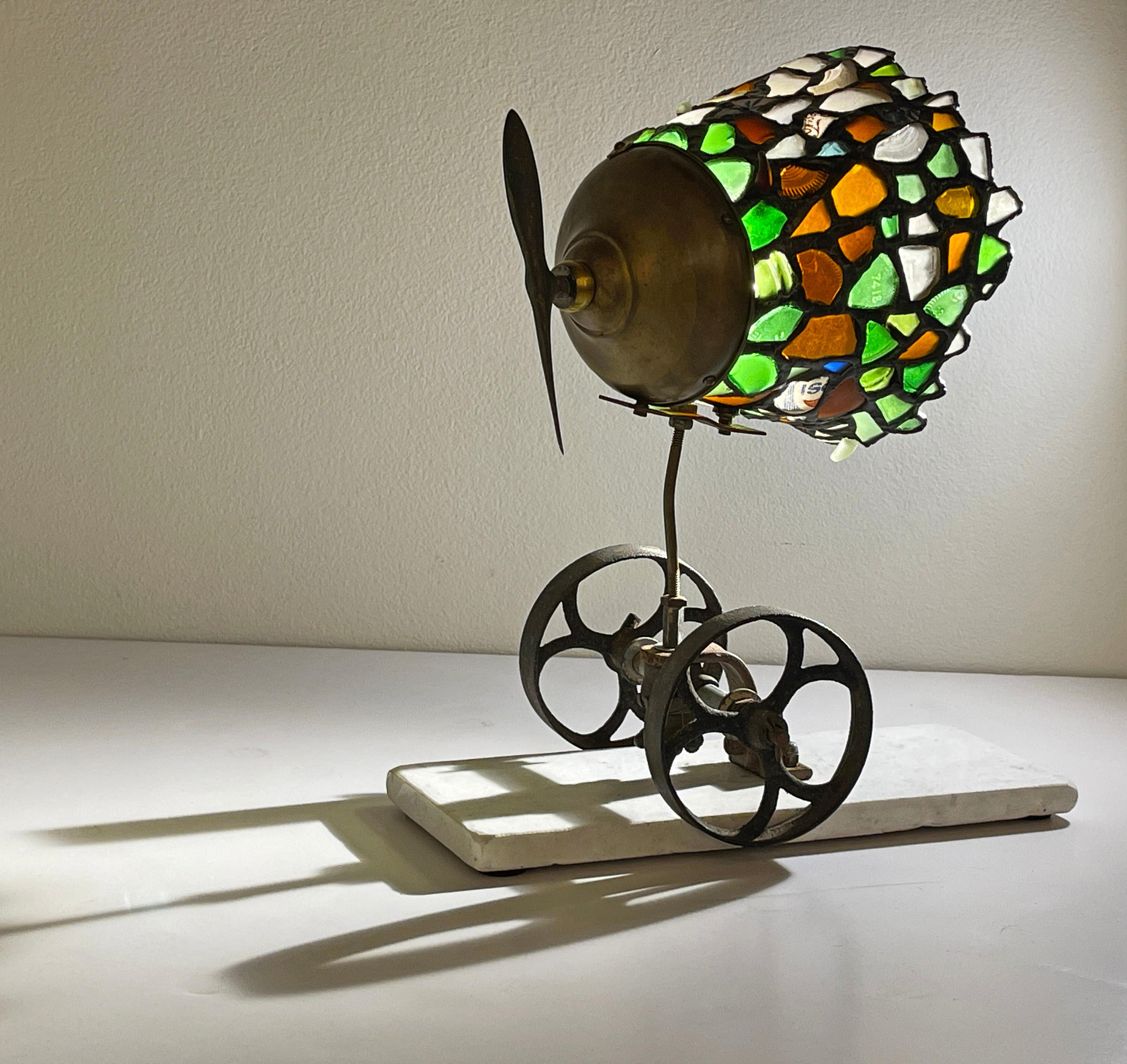 This lamp is made using salvaged Lake Michigan beach glass assembled with found objects to create this surreal and totally unique object. The artist uses the same time-honored copper foil technique employed in the creation of Tiffany lamps to obtain