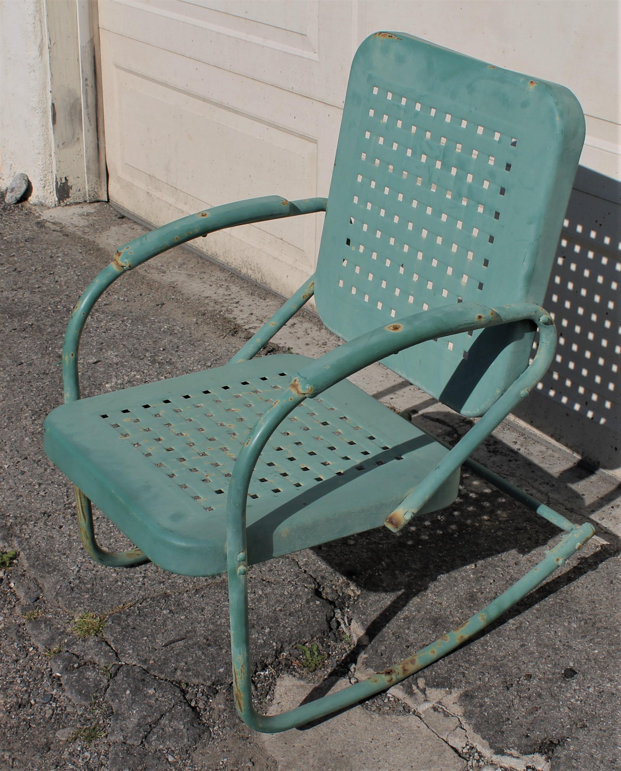 This rocking lawn chair in original painted teal surface metal. The condition is very good.