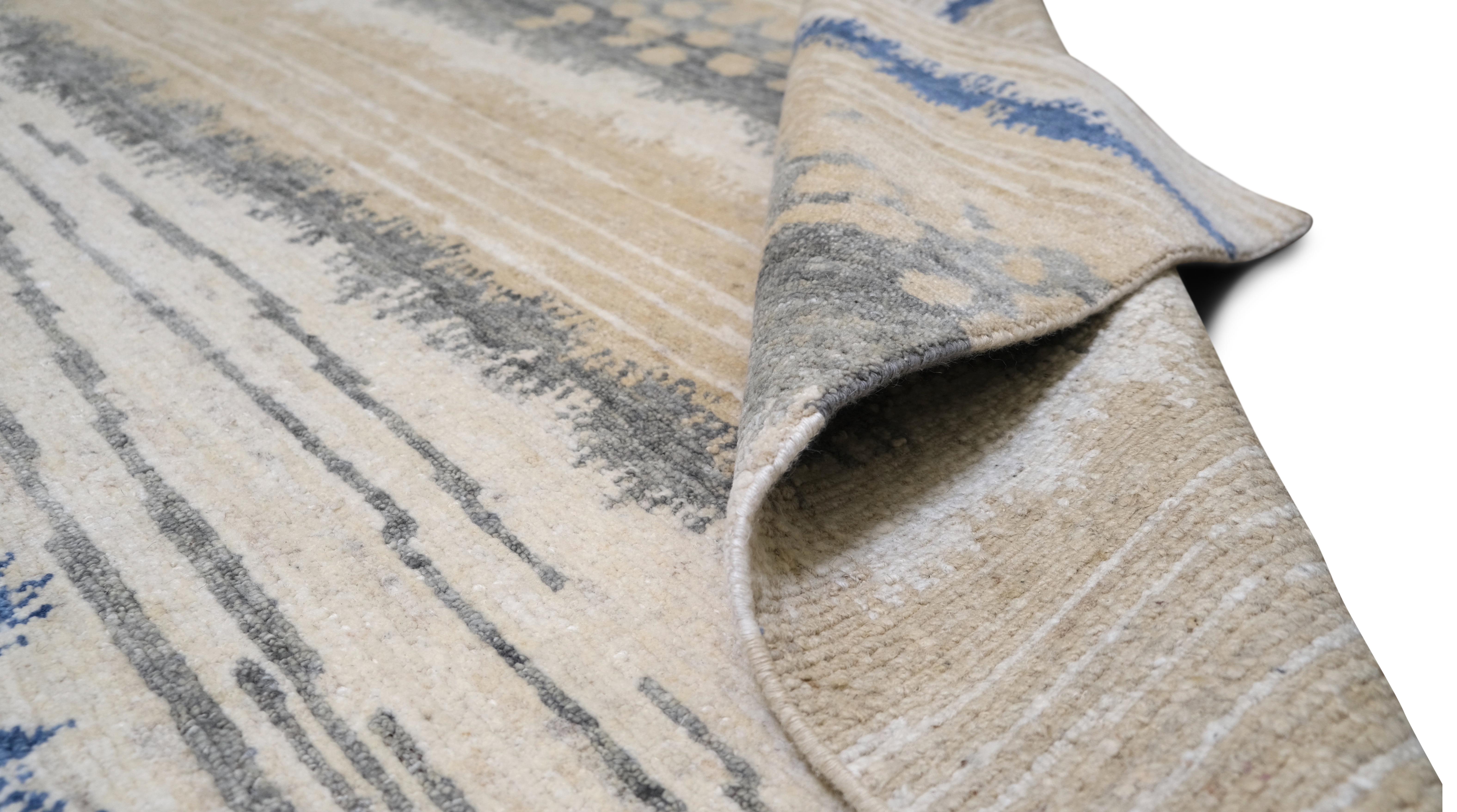 Plongez dans la beauté sereine de ce tapis en laine noué à la main. Doté d'un design rayé sophistiqué avec des tons bleus, beiges et neutres chauds, ce tapis allie l'élégance naturelle à l'esthétique moderne. Les motifs superposés évoquent l'aspect