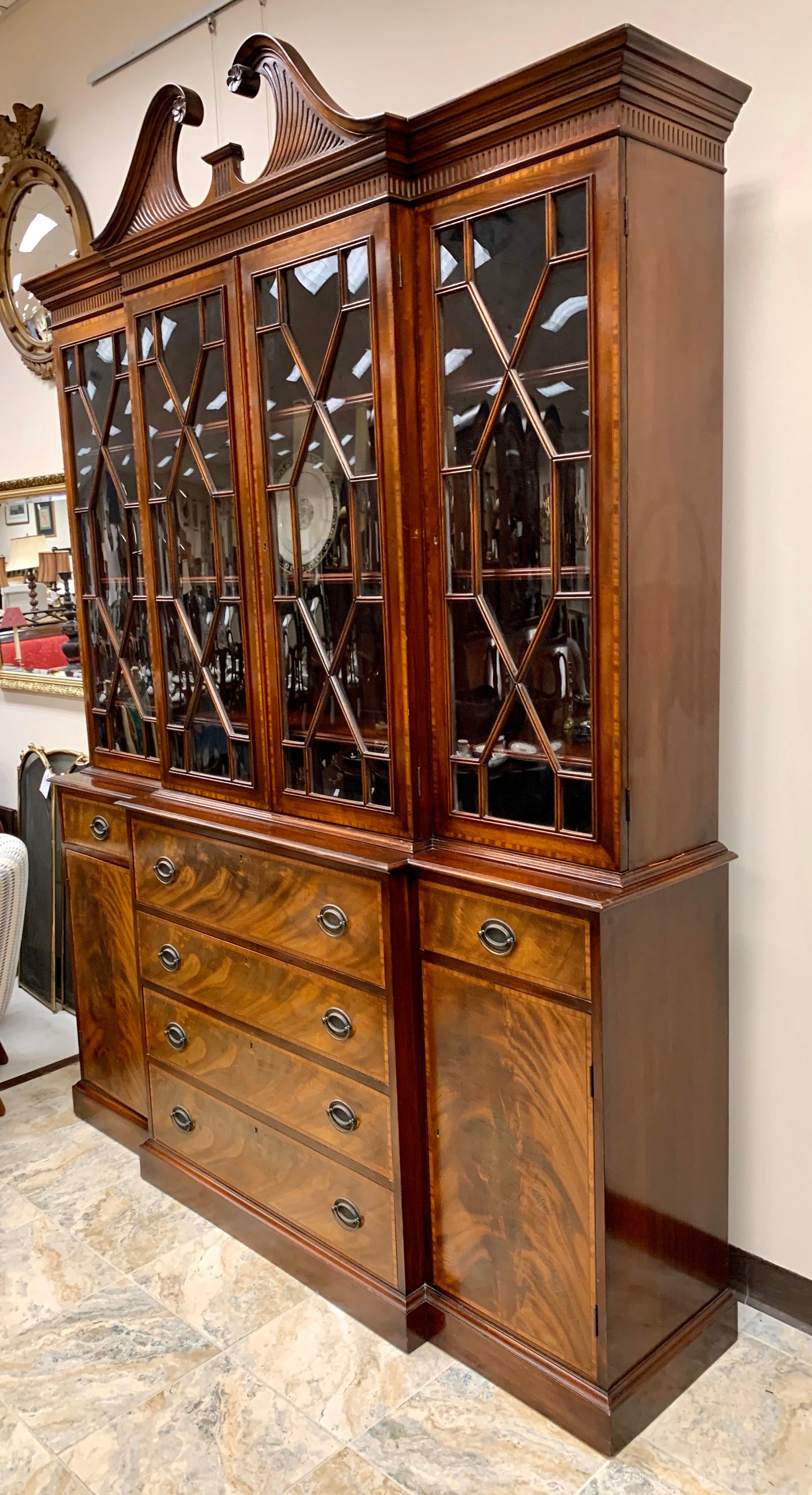 Beacon Hill collection Chippendale style 2 pc china cabinet. This flame mahogany constructed cabinet displays a broken pediment with floret accents, and four glass paneled doors just below opening to three shelves apiece. Each shelf has grooves to