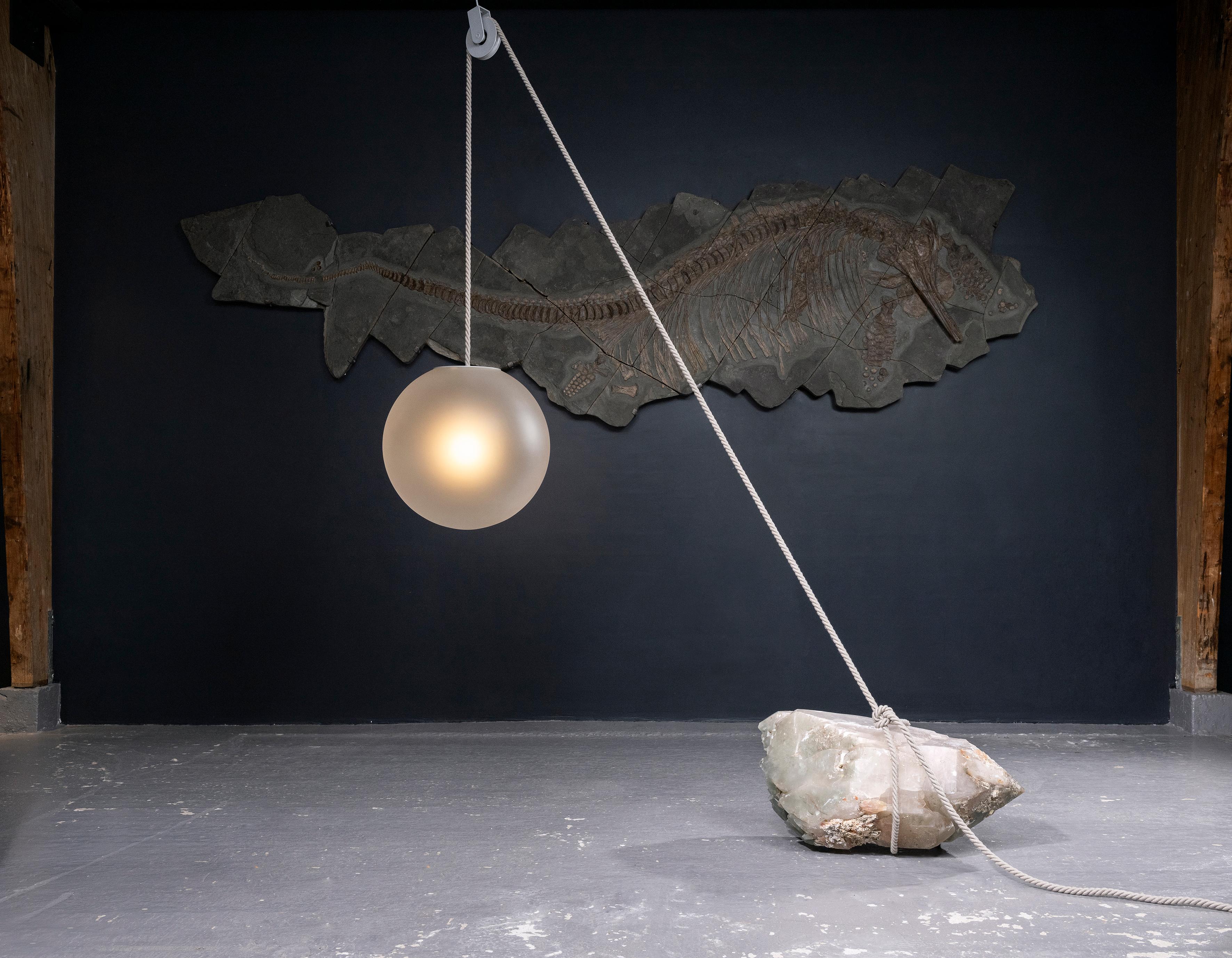 “Beacon of Light” is a design object and a functional sculpture. It gives light of hope to the lost traveller. A luminous sphere attached to a natural stone creates a delicate balance, a fulcrum in the world of confusion and uncertainty. Each stone