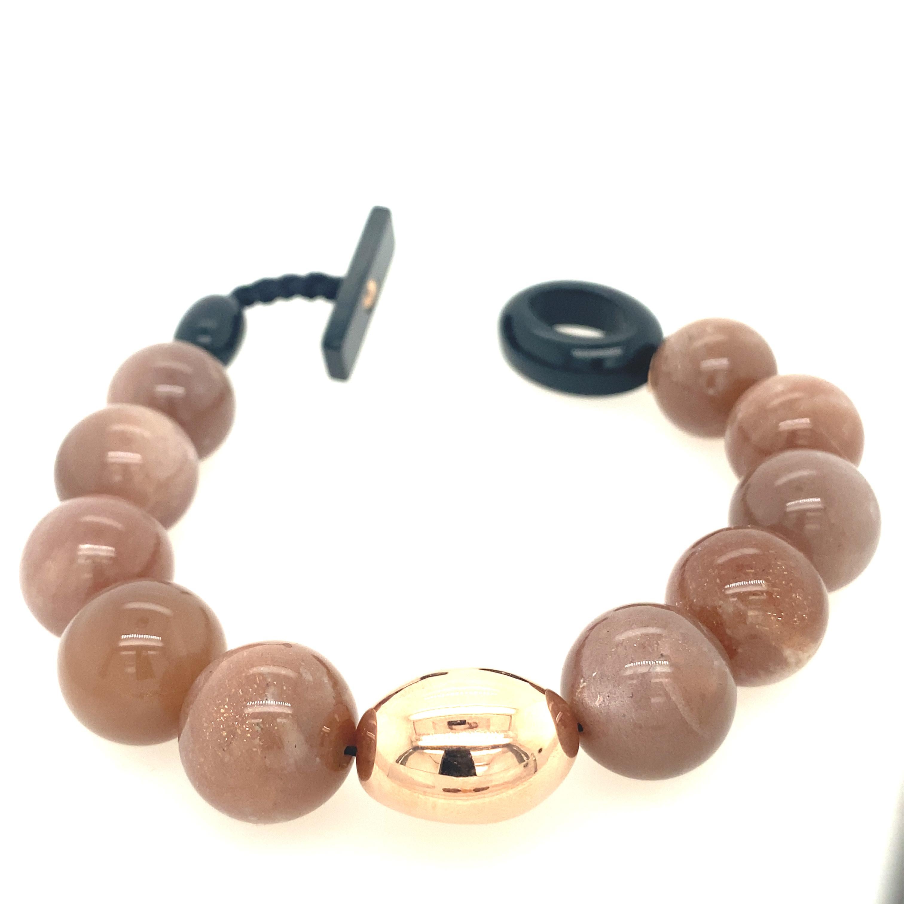 Beaded Bracelet with Peach Moonstone, Gold and Bakelite.
French Collection by Mesure et Art du Temps.

French beaded bracelet accompanied by a peach moonstone, which measures 1cm. The bracelet closes easily, the material of the closure is bakelite.
