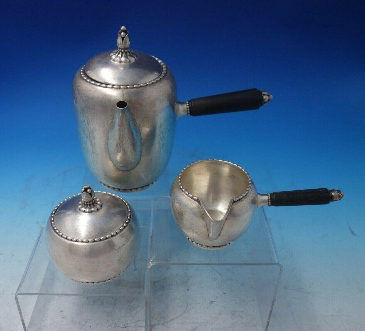 Beaded by Georg Jensen

Outstanding Beaded by Georg Jensen sterling silver three-piece chocolate pot set with GI marks featuring ebony handles. This set is marked #187 and includes:

1 - Chocolate Pot: Measures 8 1/4