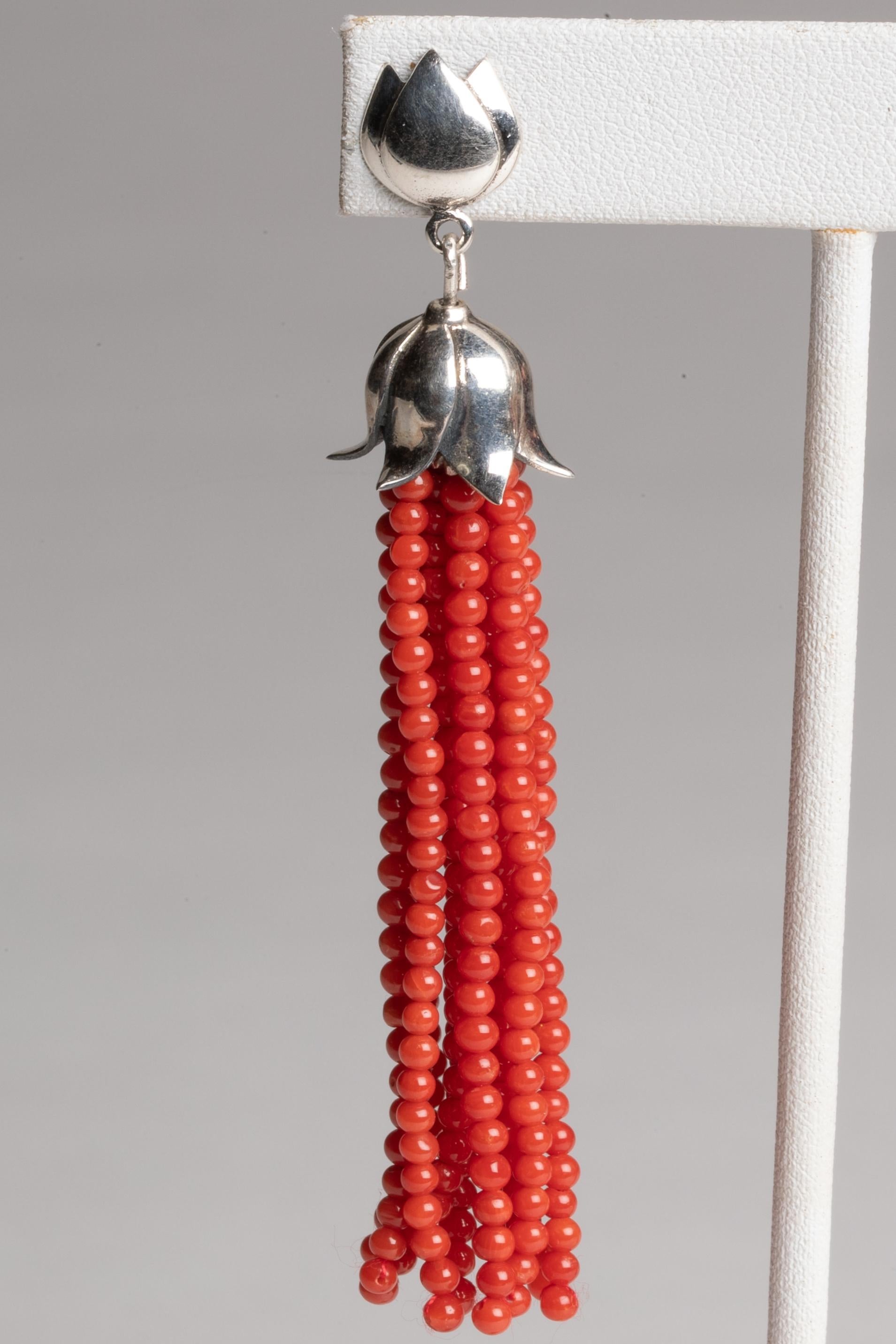 A pair of beaded coral tassel earrings with a sterling silver tulip top and post.  