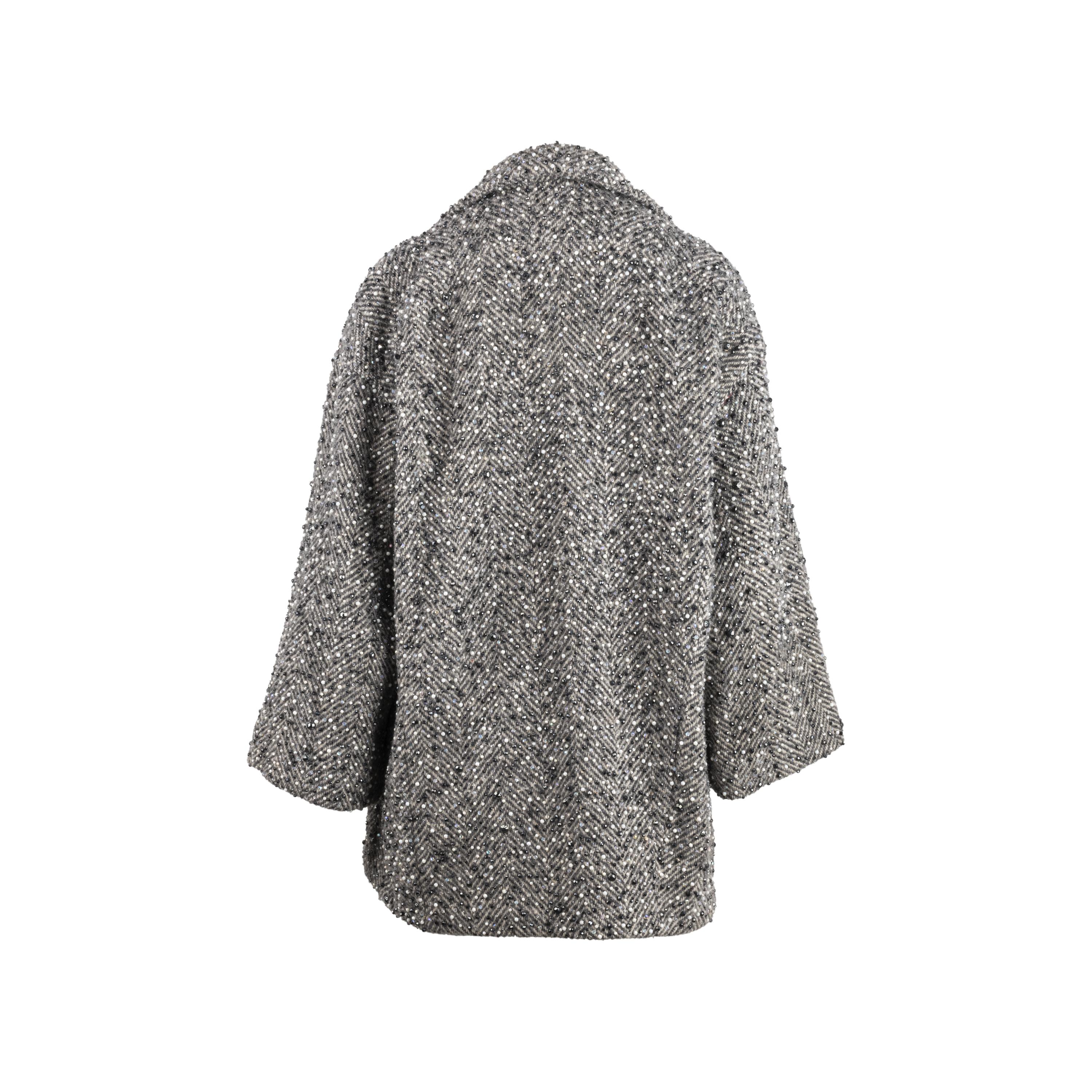 Sparkling coat designed by Gianfranco Ferré in the 80's with full coverage hand embroidery on wool tweed fabric and gray and black herringbone yarns. Embellished with gray, white and anthracite jais and rhinestones, which make this garment