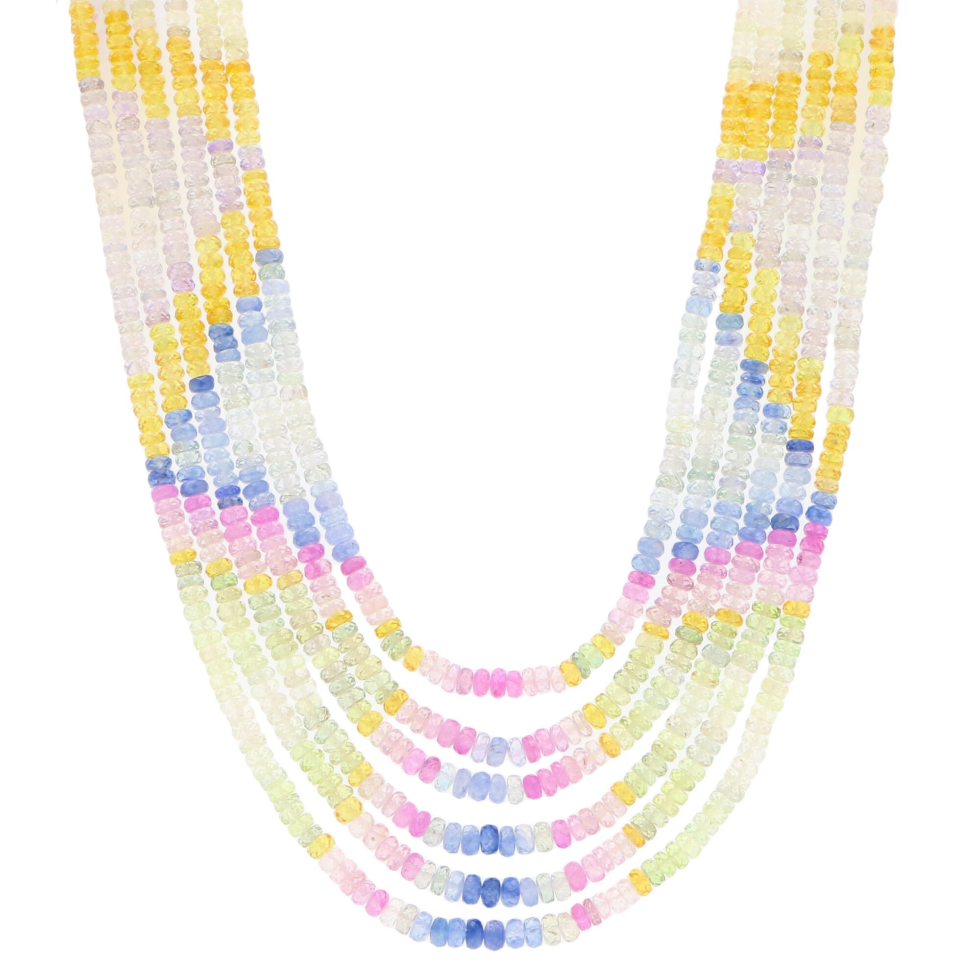 An extremely eye-catching geometric beaded rainbow sapphire necklace set with a 9k yellow gold clasp. 

The necklace is composed of six unique beaded strands all of which have a selection of pink, yellow, blue, white and green sapphire beads. Each