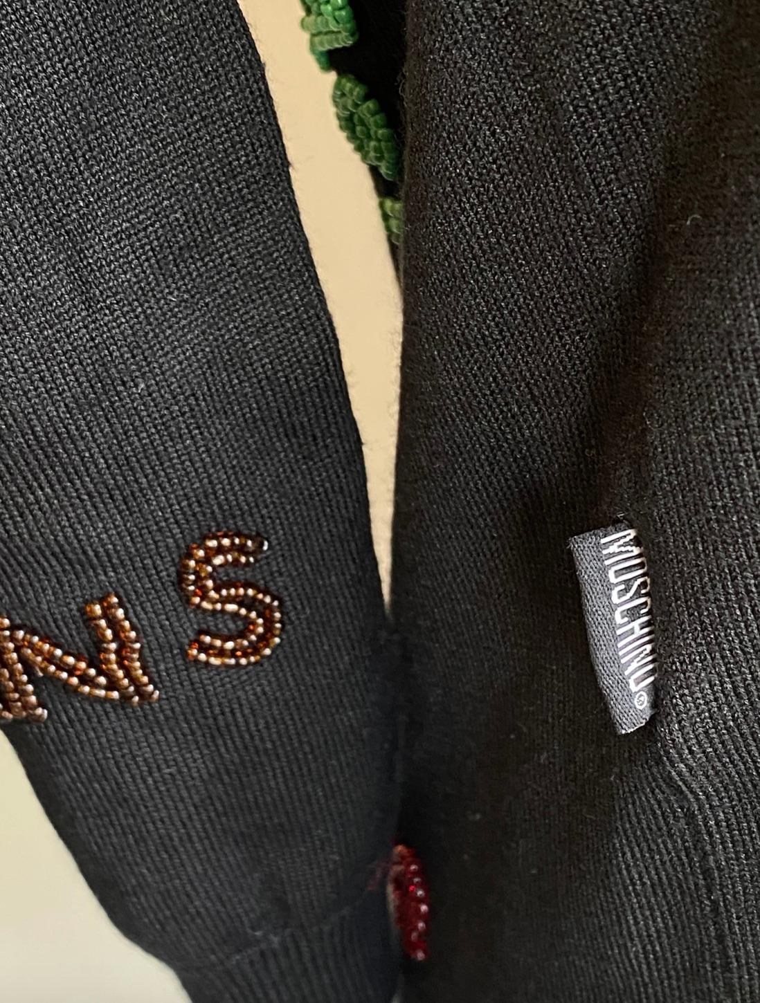 Perlenbesetztes Seidentop von Moschino Jeans. Schwarzes Oberteil aus einer Seidenmischung, verziert mit mehrfarbigen Perlen, auf denen 