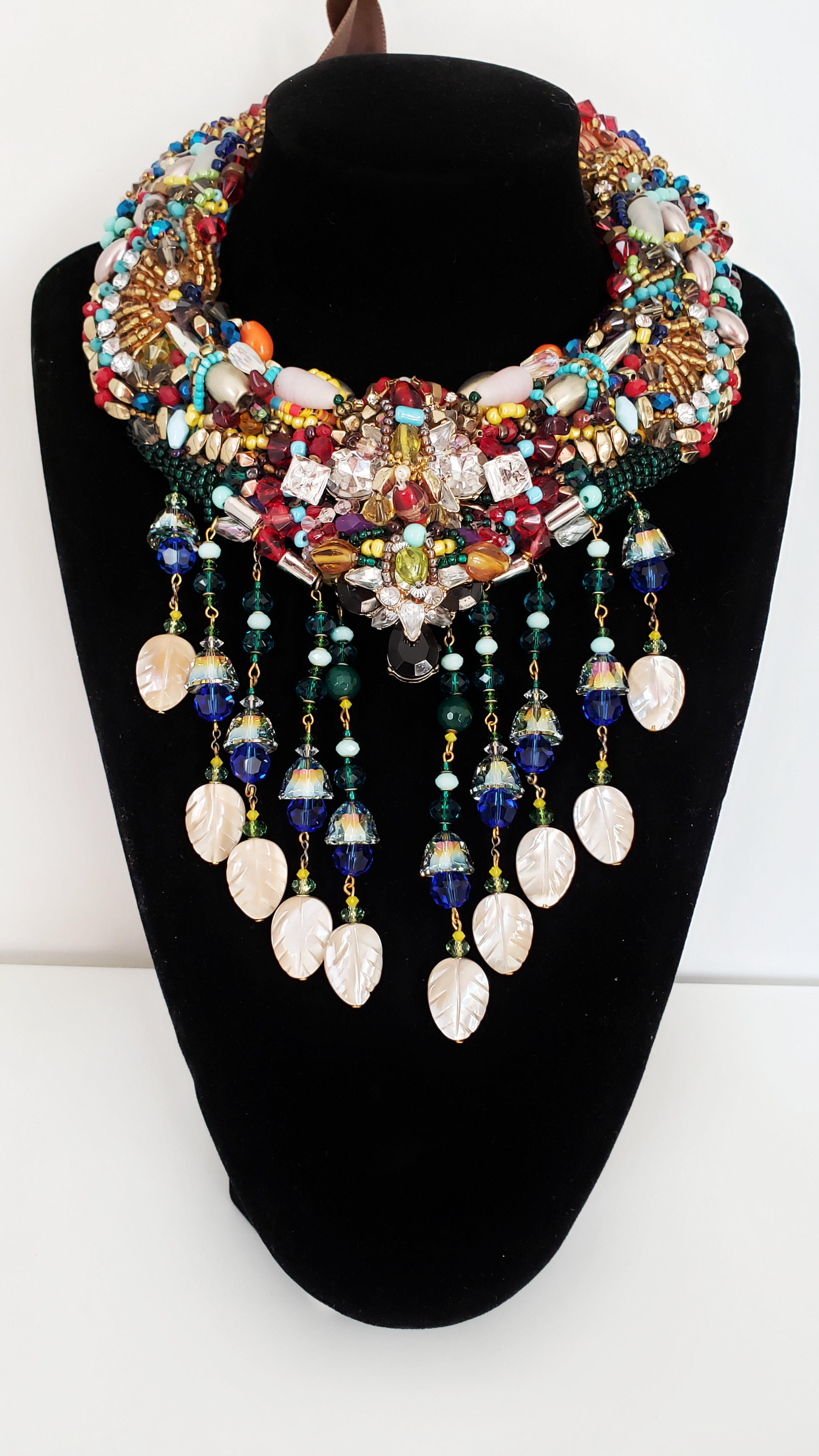 This superbly stylish multi-beaded Swarovski embellished mother-of-pearl tassel drop statement necklace boasts tonnes of vibrancy, colour combination and detailing.

This necklace features a striking combination of assorted glass beads, acrylic