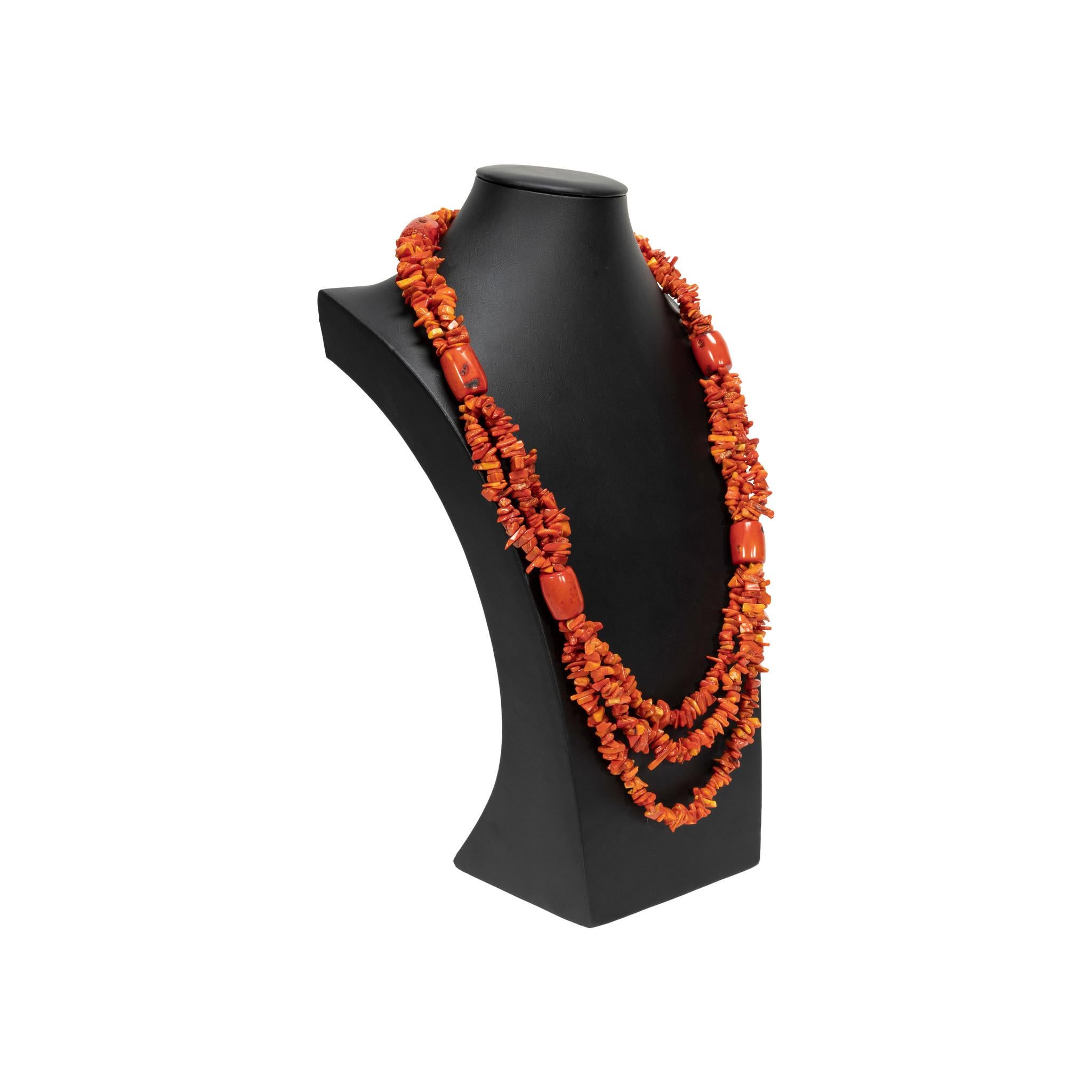 Collana di corallo rosso a tre fili con perline. Ogni filo è interamente impreziosito da perline di corallo rosso scheggiato. Sei grandi perle di corallo che si uniscono a fili, distanziati in modo uniforme per tutta la collana. Il corallo è un