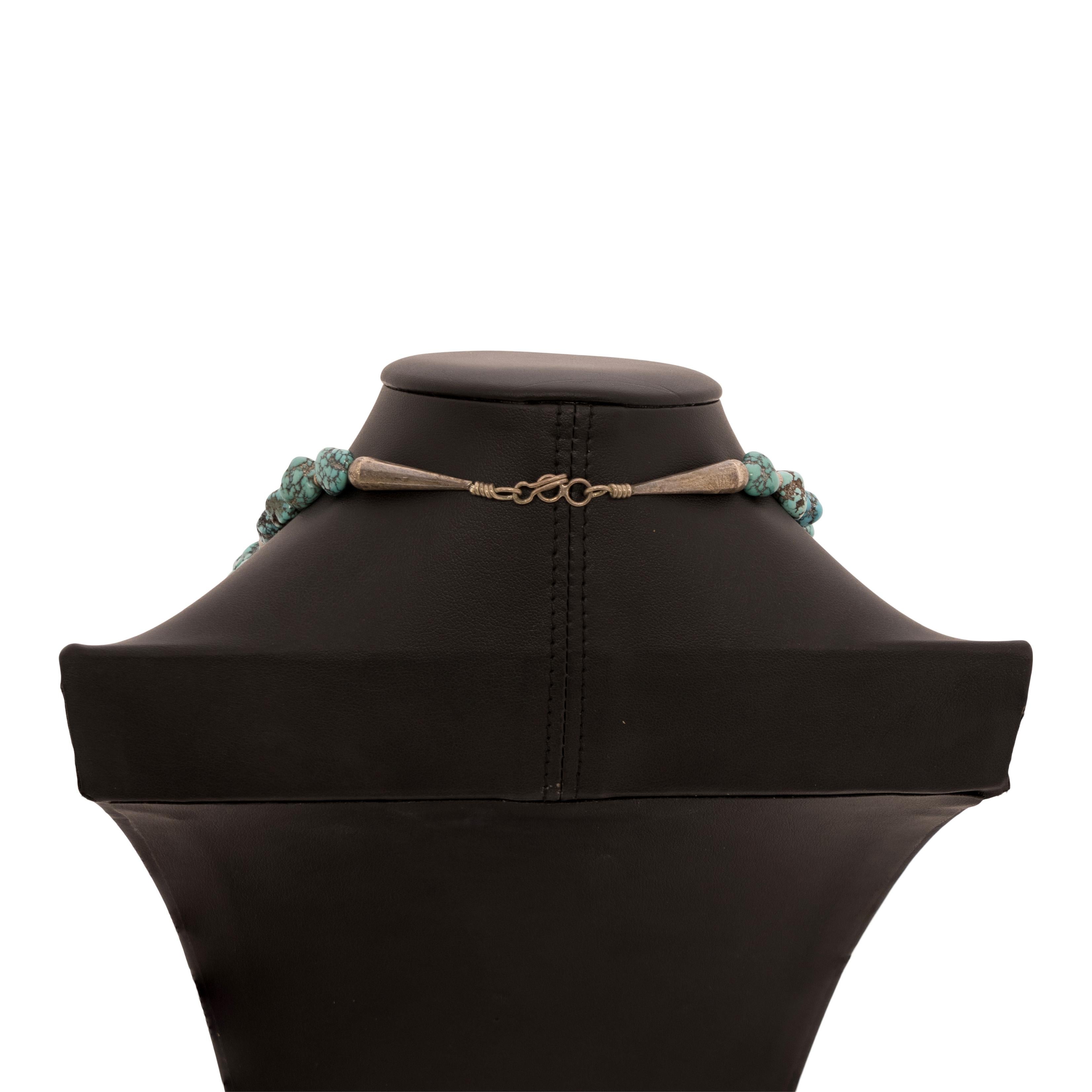 Beaded turquoise nugget necklace. Five large stones interspersed with small turquoise nugget beads and sterling bead accents. With hook close attached to sterling end caps. Turquoise is a classic blue color with veins of dark matrix. Natural stones,