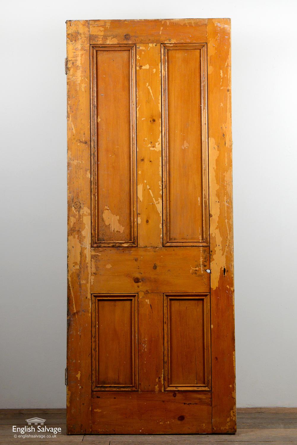 Salvaged interior pine door with four beaded panels and two old hinges. Handle, lock and nail holes present.